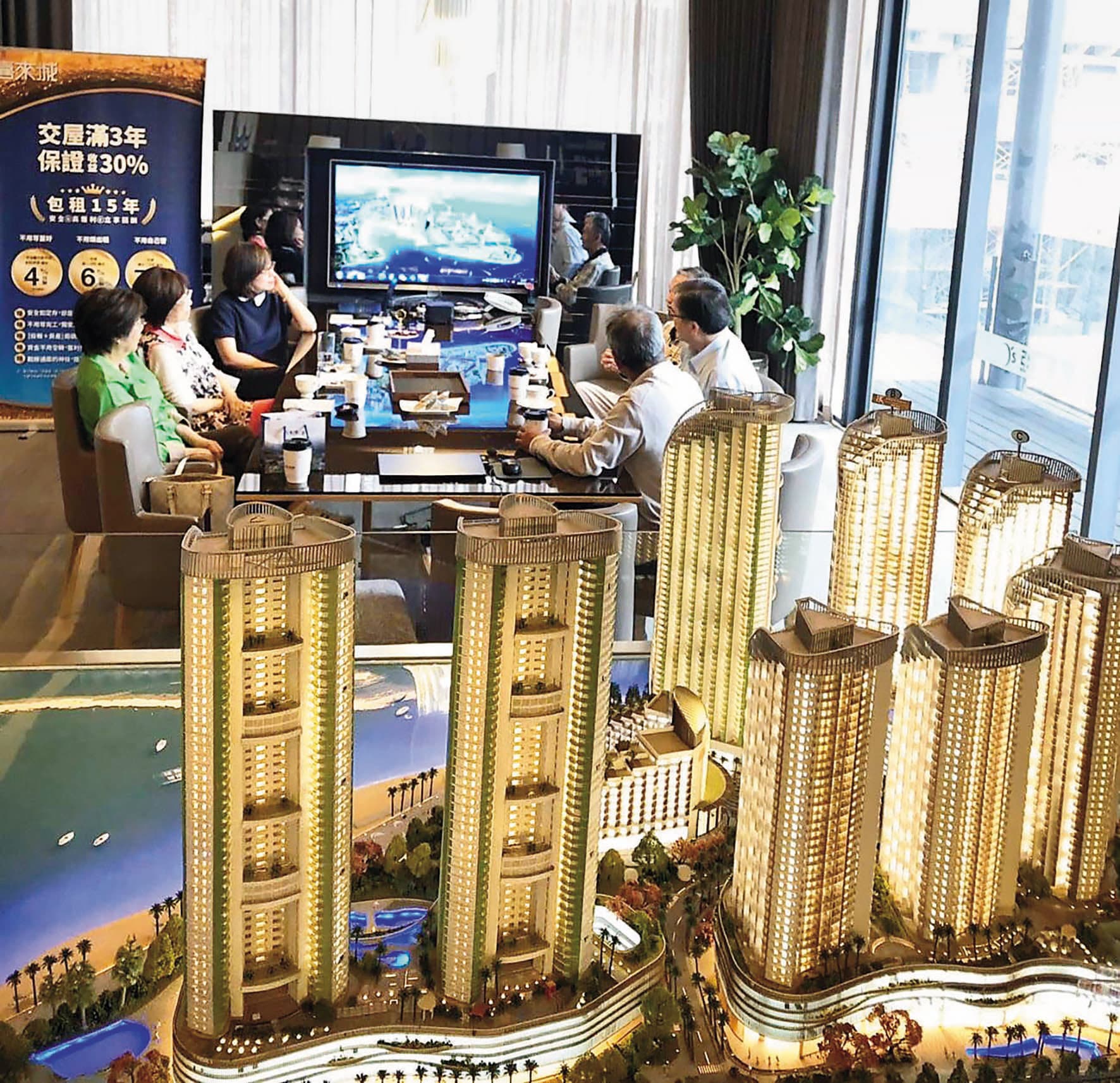 亞昕The Rise銷售中心展示模型，現場接待人員向客戶介紹建案。