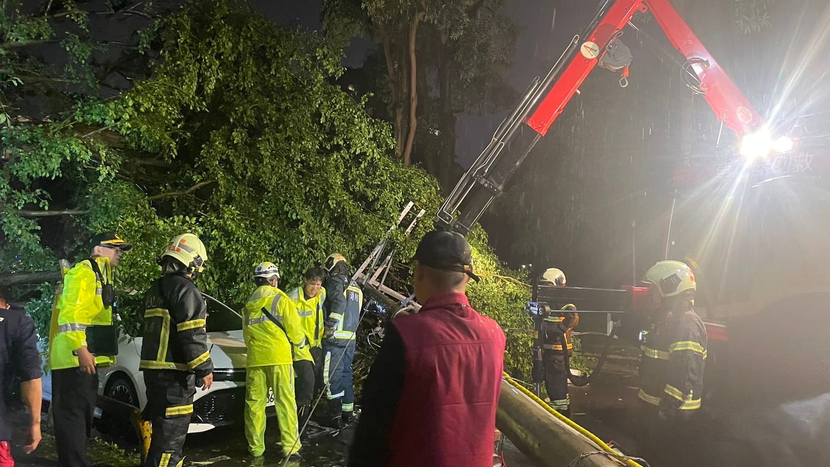 警消利用吊臂及破壞工具將被壓在電線桿下的羅男救出。（翻攝畫面）