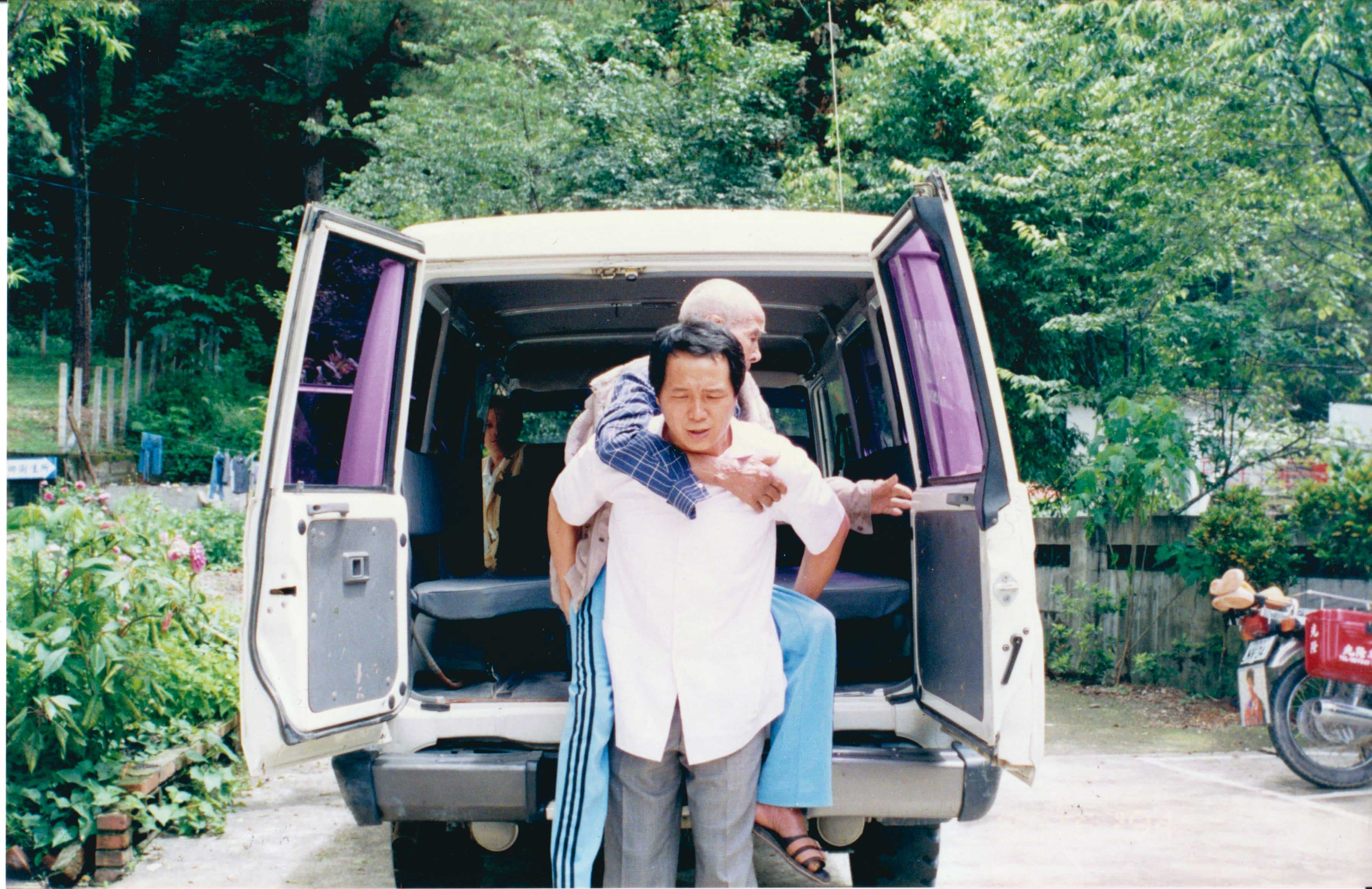 深山行醫資源不充足，賴力行（前）親力親為，還會自己背著年長病患移動。（賴力行提供）