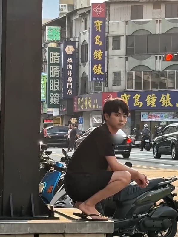 佐藤勝利穿著黑色短袖與短褲，腳踩夾腳拖，隨性蹲坐在路邊。（翻攝自instagram＠shori_sato_official）