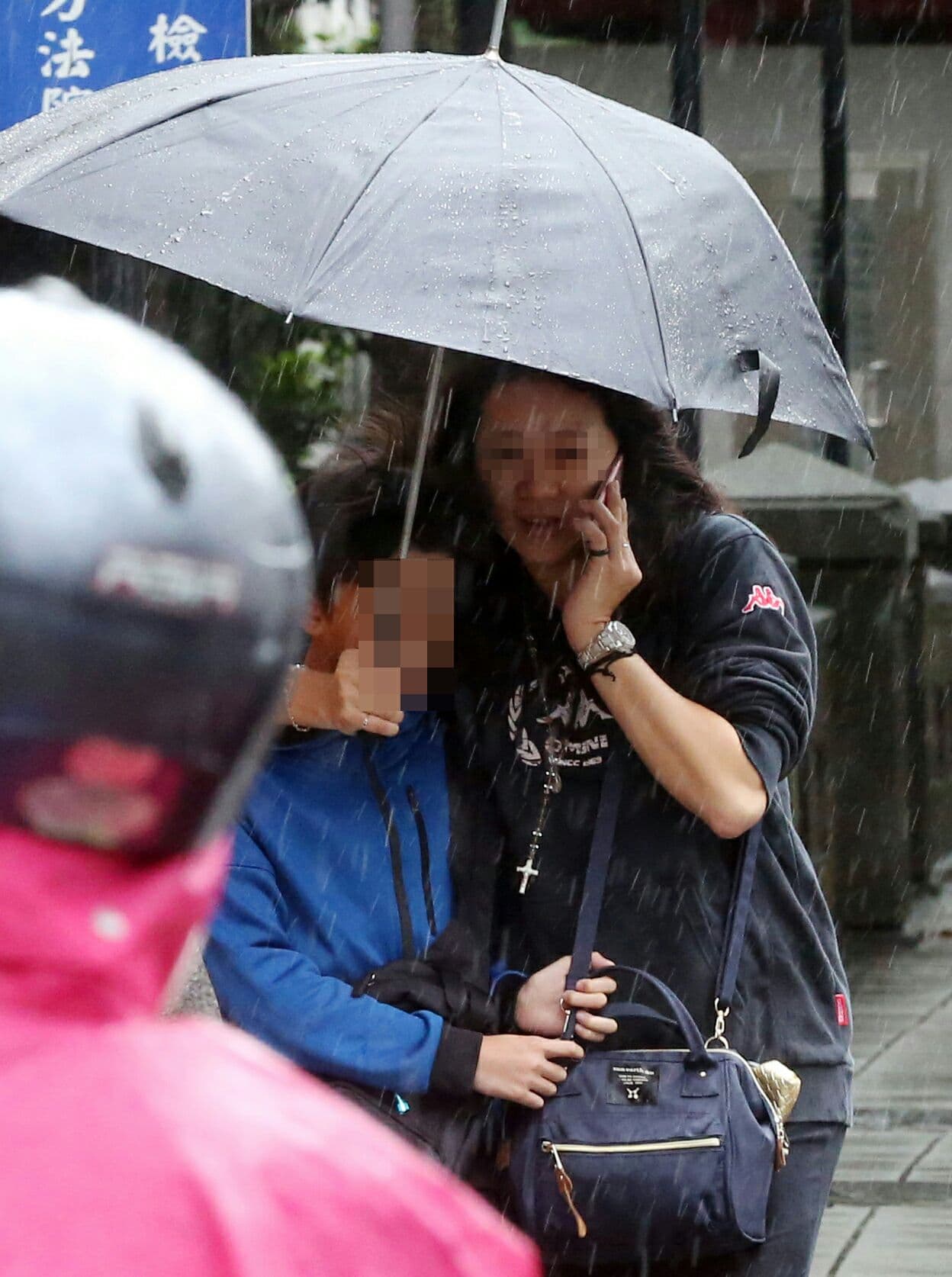 李姓超跑業務元配擔心孩子淋雨著涼，還貼心地替孩子撐傘。