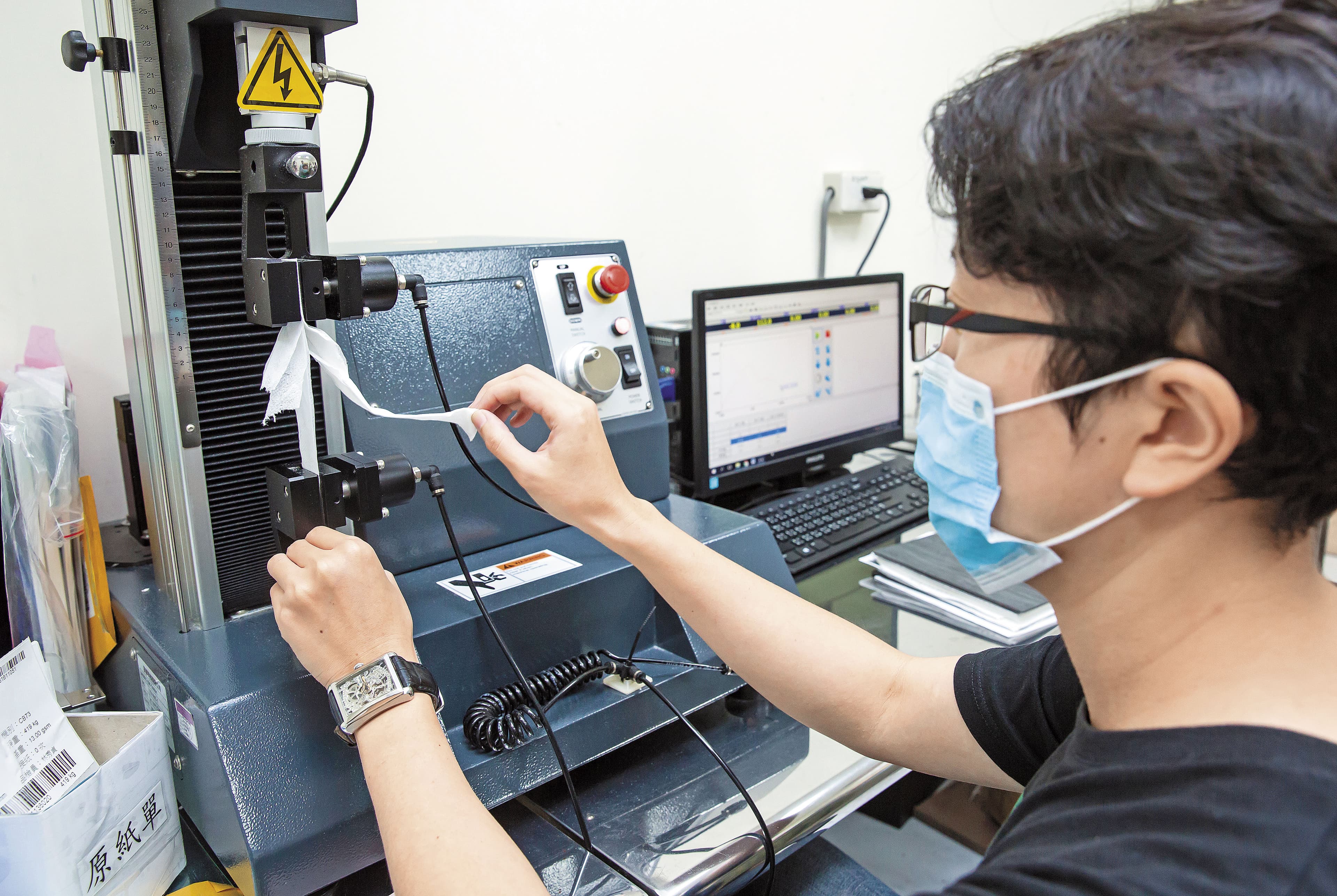 新豐是國內少數取得CNS認證衛生紙工廠，也設有實驗室。圖為品保人員測試衛生紙拉力。