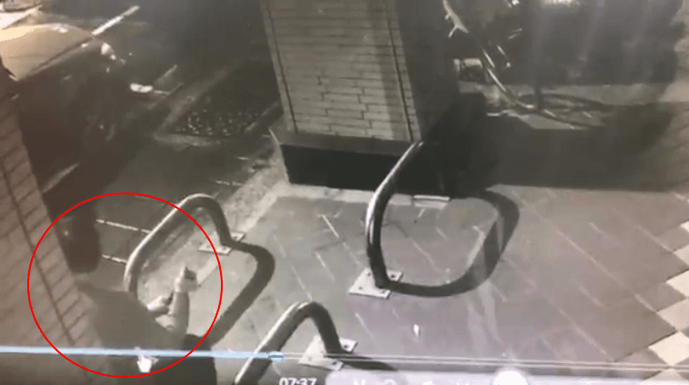 林男坐在路旁的護欄上，不斷轉動手中的警棍，在找尋下手最佳時間點。