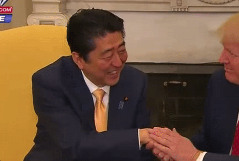 川普與日本首相安倍晉三握手。