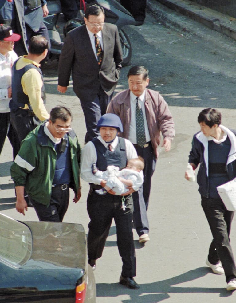 陳進興持槍挾持南非武官卓懋祺一家6口，現為新北市副市長的侯友宜（右）與台北市警察局長邱豐光（左），當時冒險進屋抱出小孩。（達志影像）