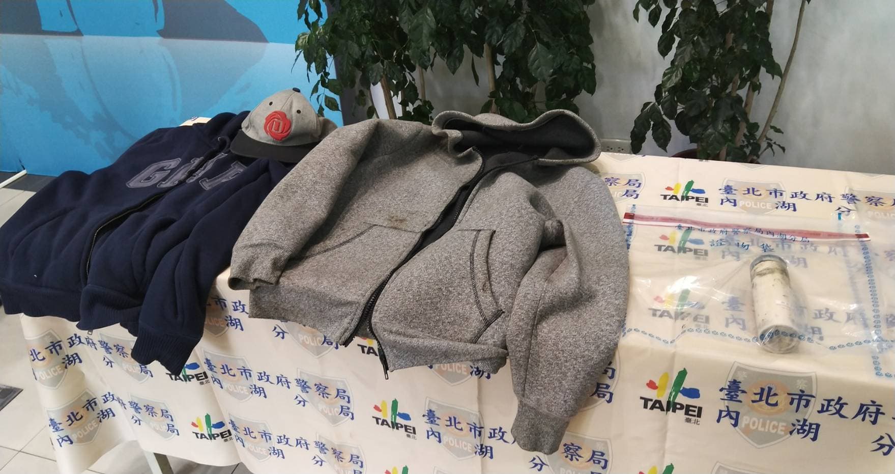 兩名大學生埋伏作案時的外套，一旁是用來裝瀝青潑灑的大瓶口咖啡罐。（翻攝畫面）