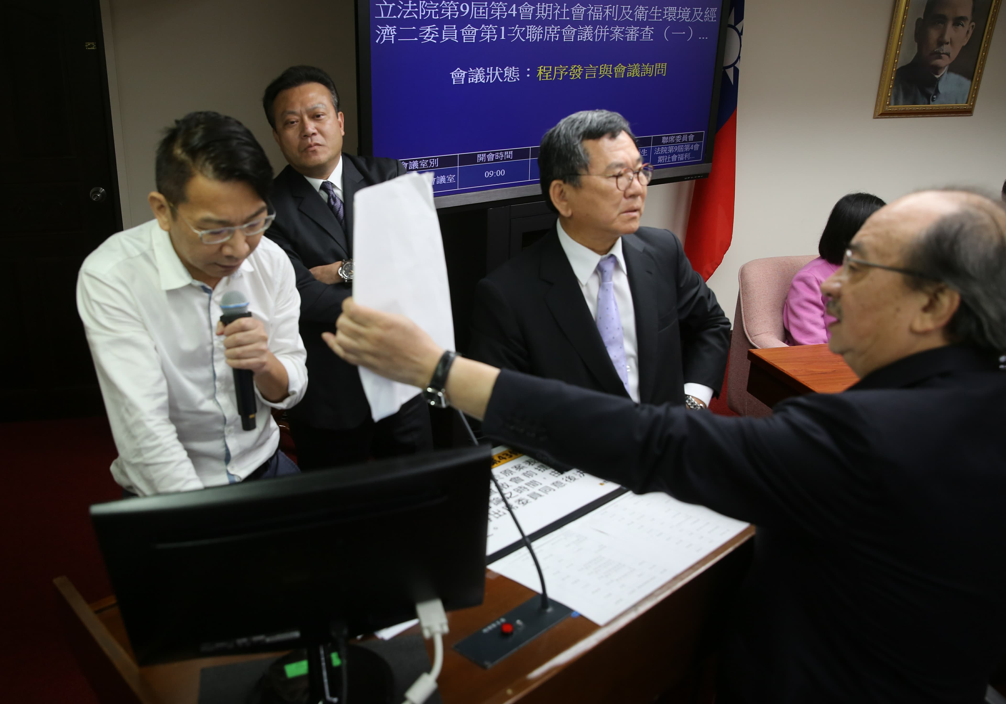 時代力量立委徐永明（左）今會議不斷霸佔發言台，不讓會議進行。
