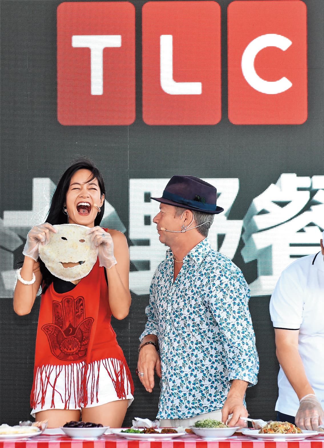 Janet（左）的魅力在於，就算是出包了，效果反而會更好。例如她跟伊恩萊特（右）同台示範潤餅，卻把潤餅意外做成了面膜。（TLC旅遊生活頻道提供） 