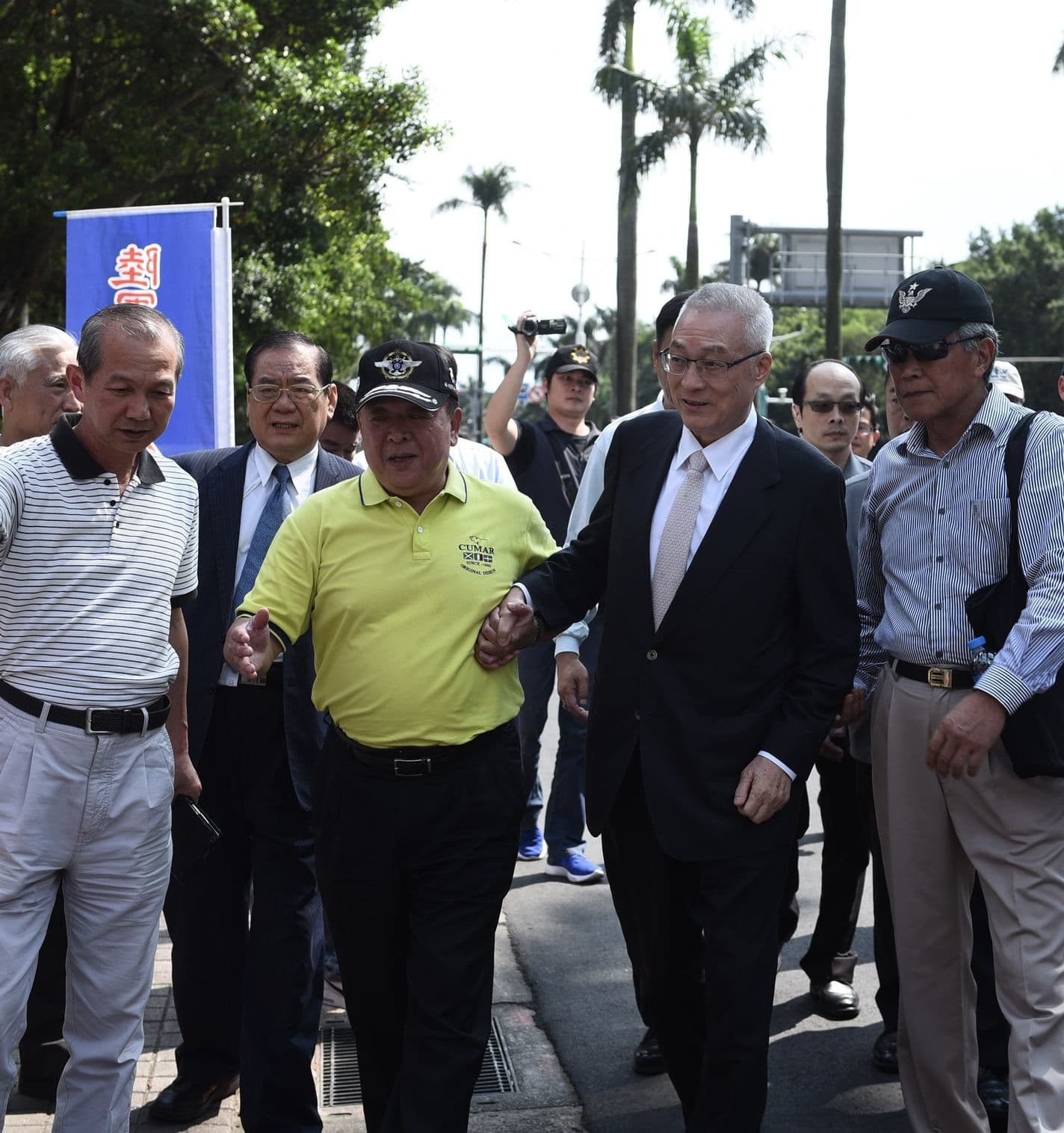 國民黨主席吳敦義最近身體不適，日前赴立法院為反年改團體「八百壯士」加油，還需八百壯士副指揮官吳斯懷攙扶。（翻攝臉書）