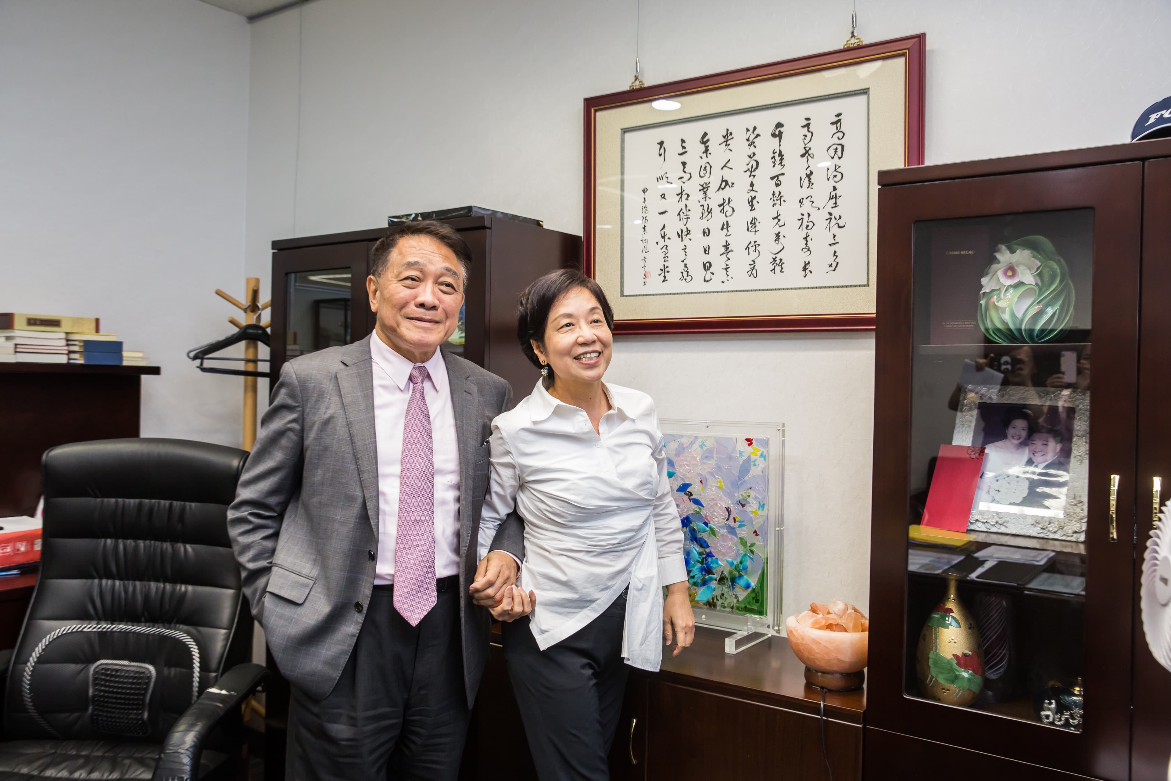 楊克誠（左）的辦公室裡，掛著一幅陳素甜（右）提詞的賀詩。