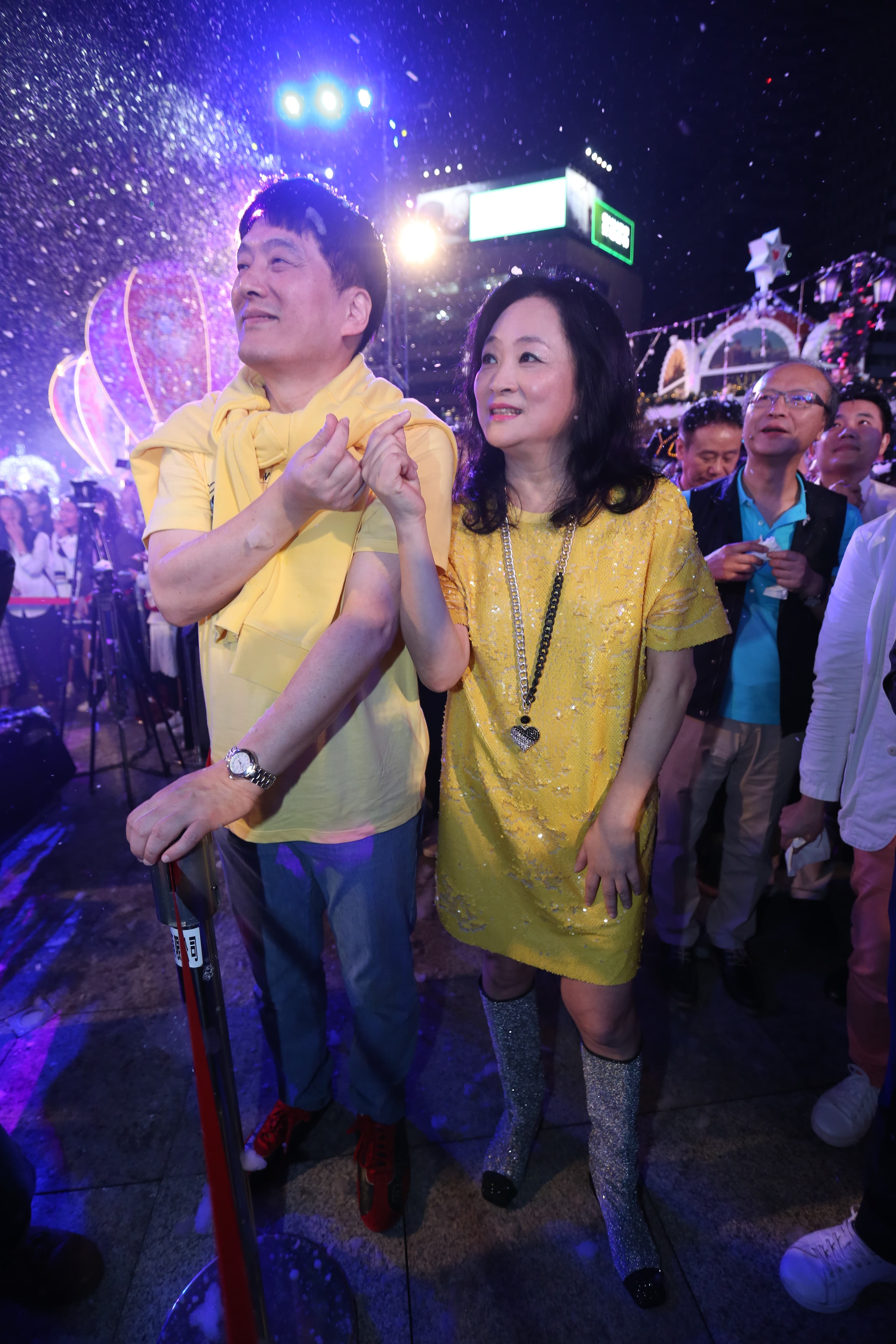 穿上縫有亮片的黃色洋裝、腳踩銀色閃亮亮的靴子，統一美麗事業董事長高秀玲（右）與羅智先一同出席「愛．Sharing」愛分享點燈活動。