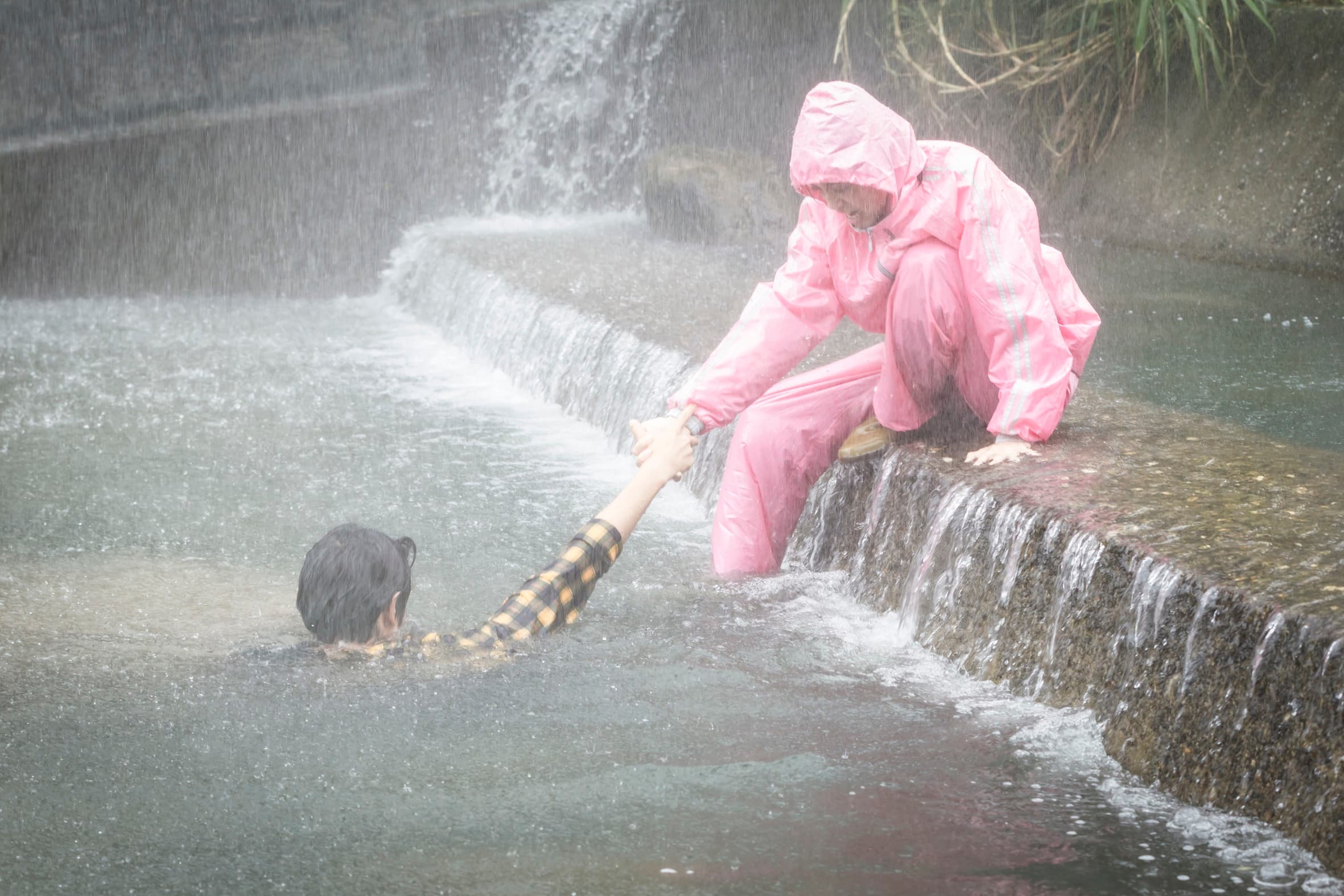 陳庭妮穿著粉紅色雨衣救起溺水的劉以豪。（歐銻銻娛樂提供）