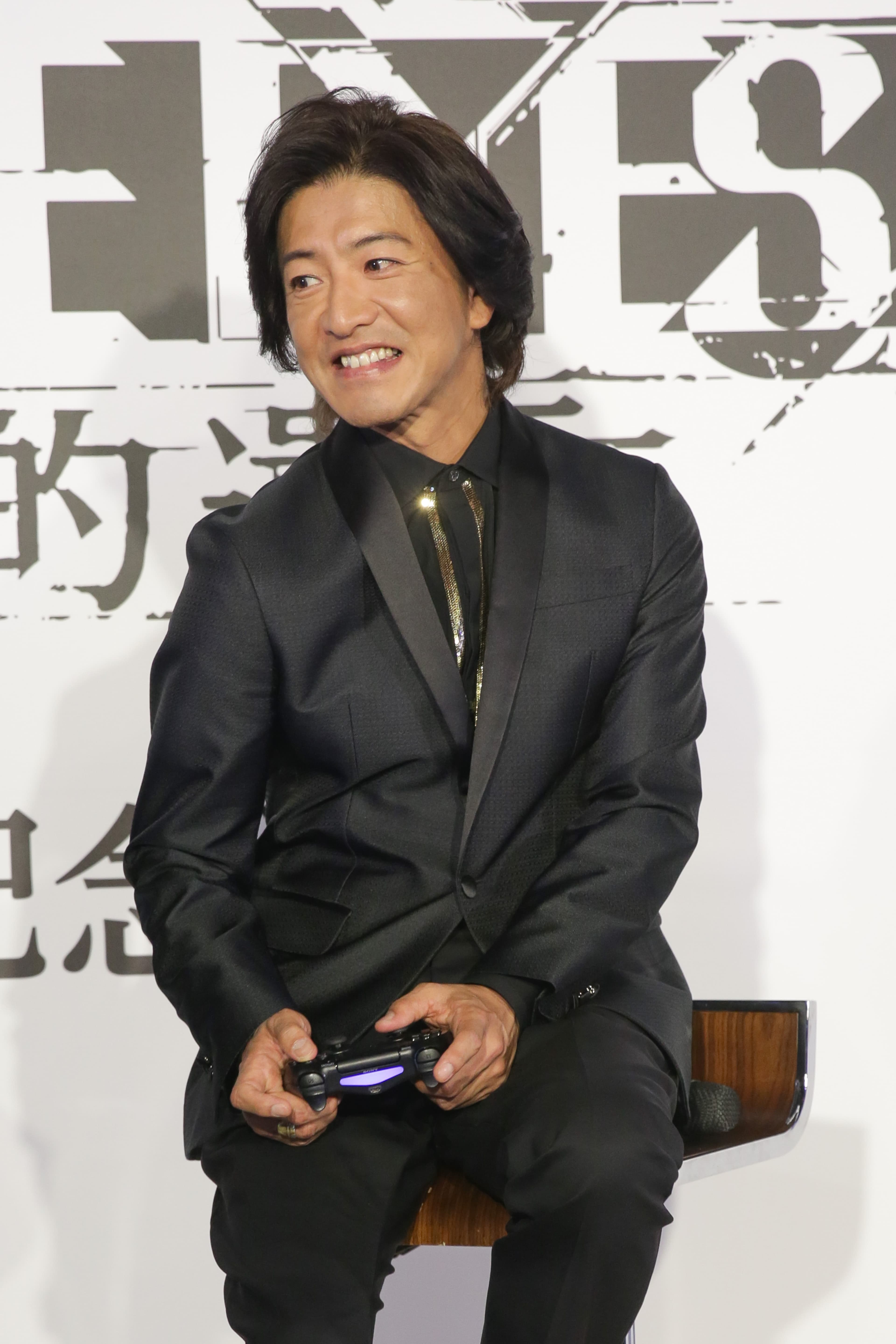 木村拓哉專注在遊戲《審判之眼：死神的遺言》，還扭了一下肩膀，常玩電玩的朋友都很熟這個動作。