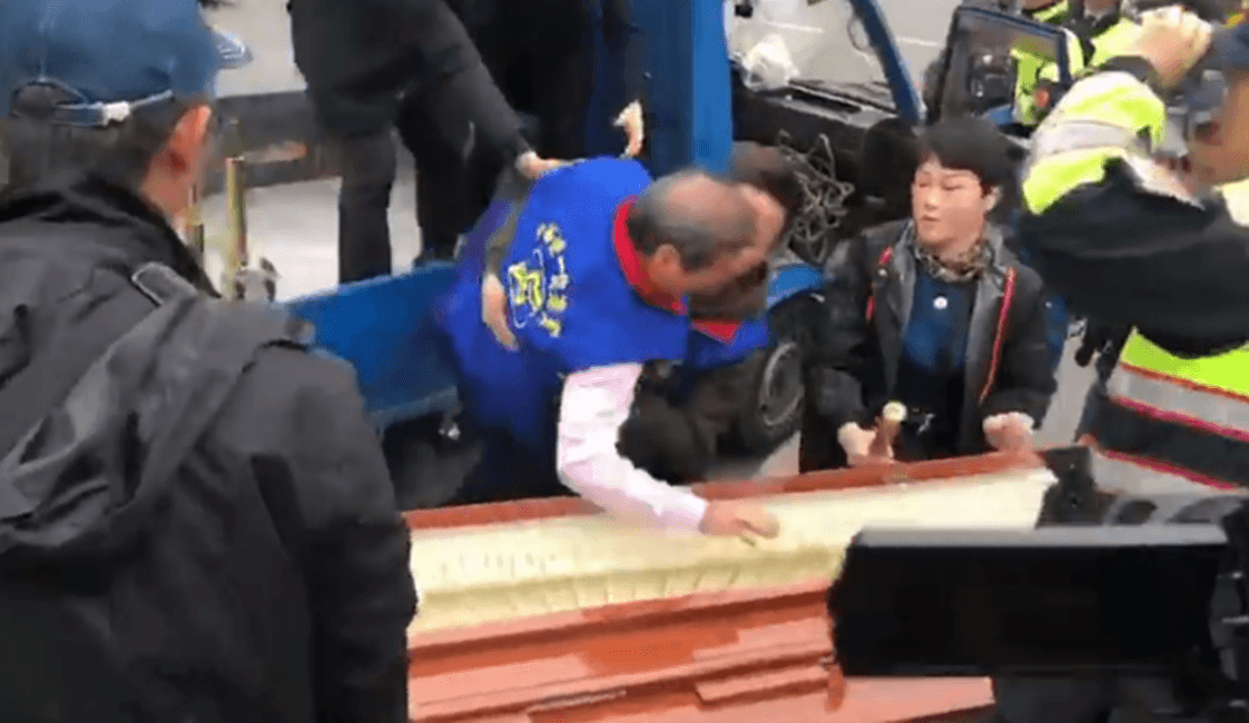 張安樂率眾到立法院抬棺抗議，從貨車上跌下來。（翻攝自《奉命刑事》臉書）