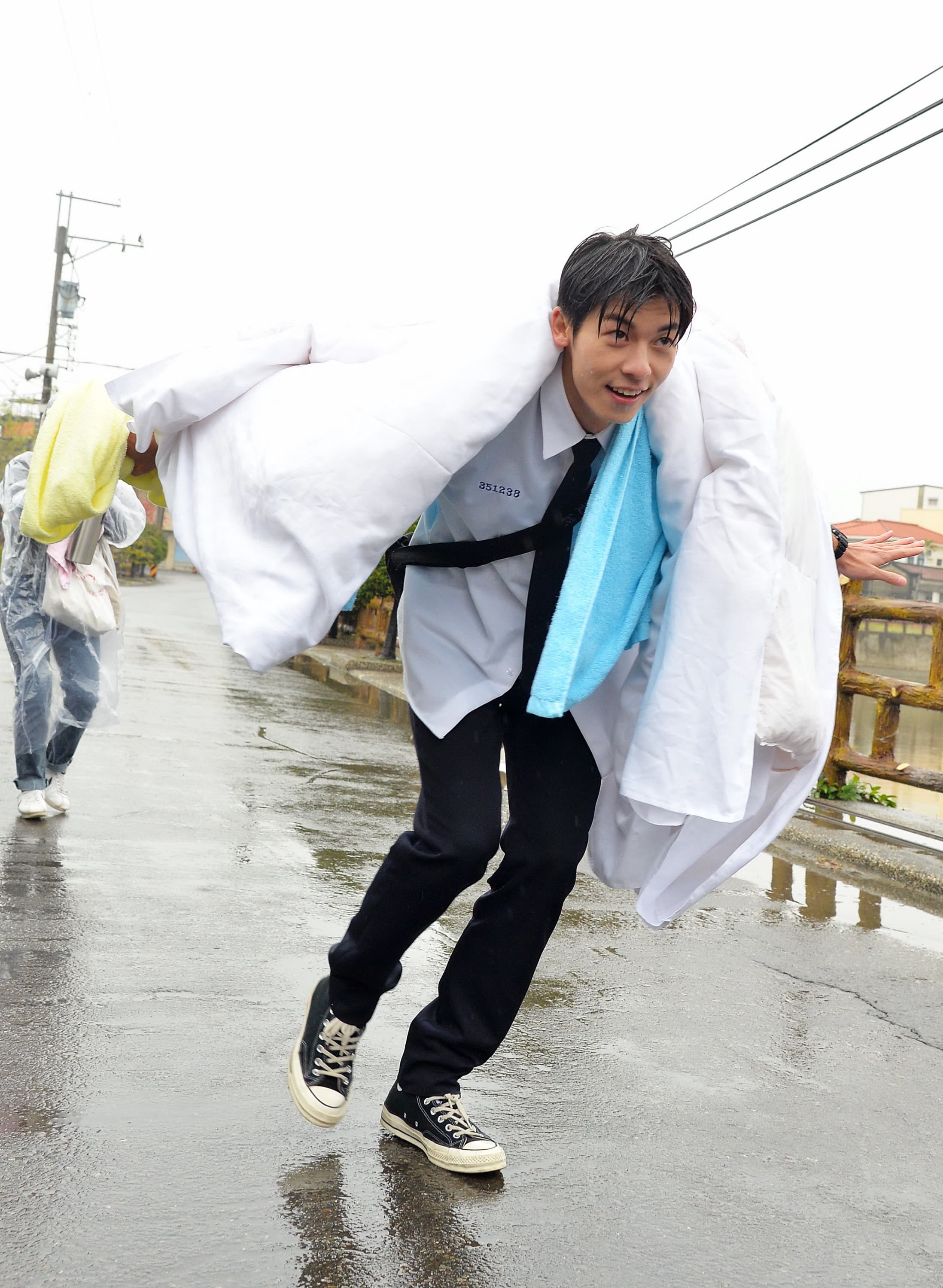 許光漢在大雨中披棉被走秀裝名模。（福斯傳媒集團提供）