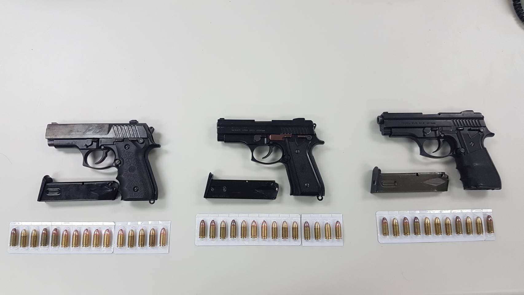 李嫌腰際緝獲的3枝改造手槍與附有彈匣及子彈40顆。（警方提供）