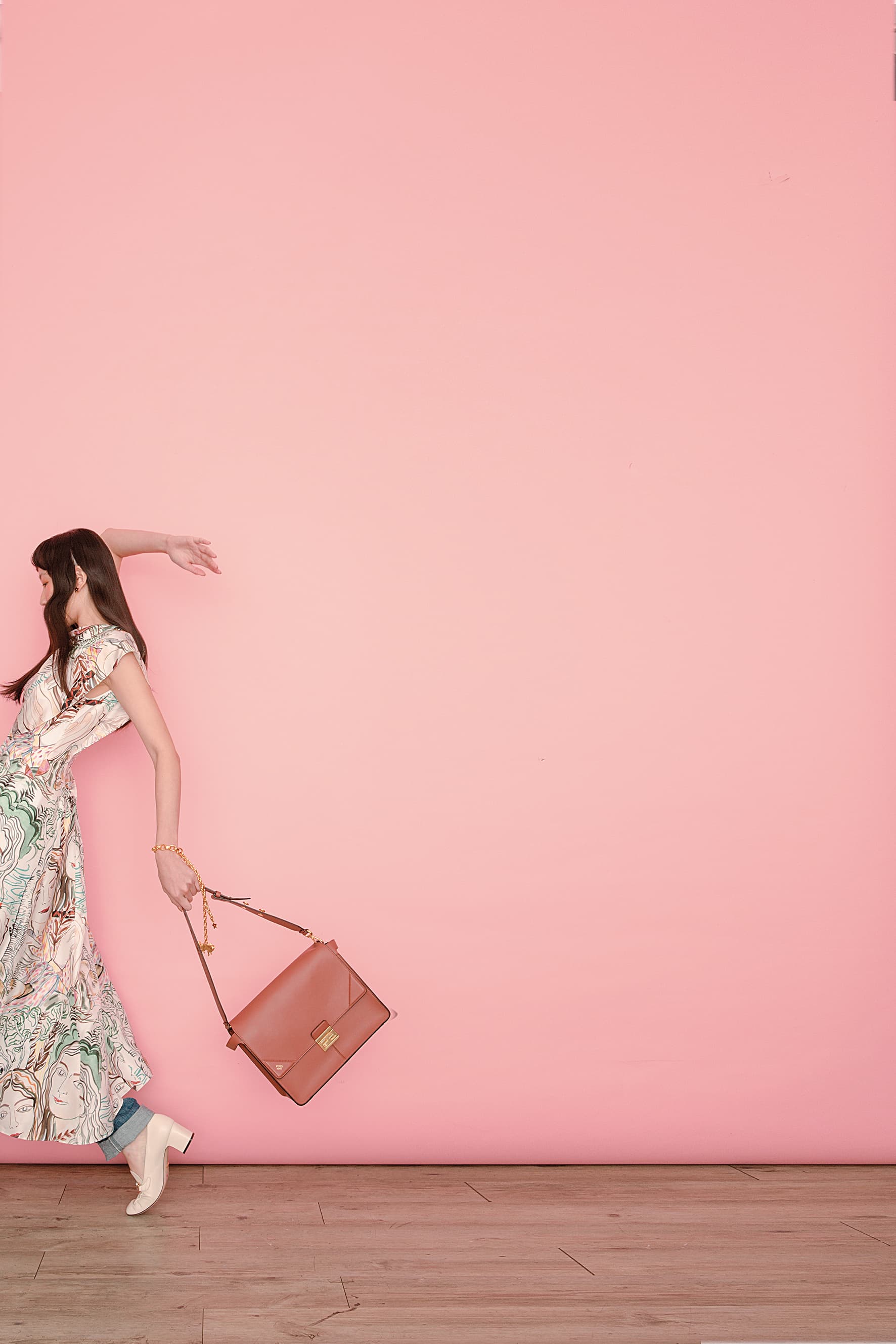 駝色KAN U提包 NT$98,000 by FENDI；不對稱絲質印花洋裝 NT$43,000 by 3.1 PHILLIP LIM；丹寧褲 NT$23,000 by LOEWE；白色馬銜鍊高跟鞋 NT$30,500 by GUCCI；Zodiaddict 灰色雙子座珍珠不對稱耳飾 NT$22,000 by DIOR；Zodiaddict 金色雙子座垂墜項鍊（當手鍊用） NT$62,000 by DIOR。