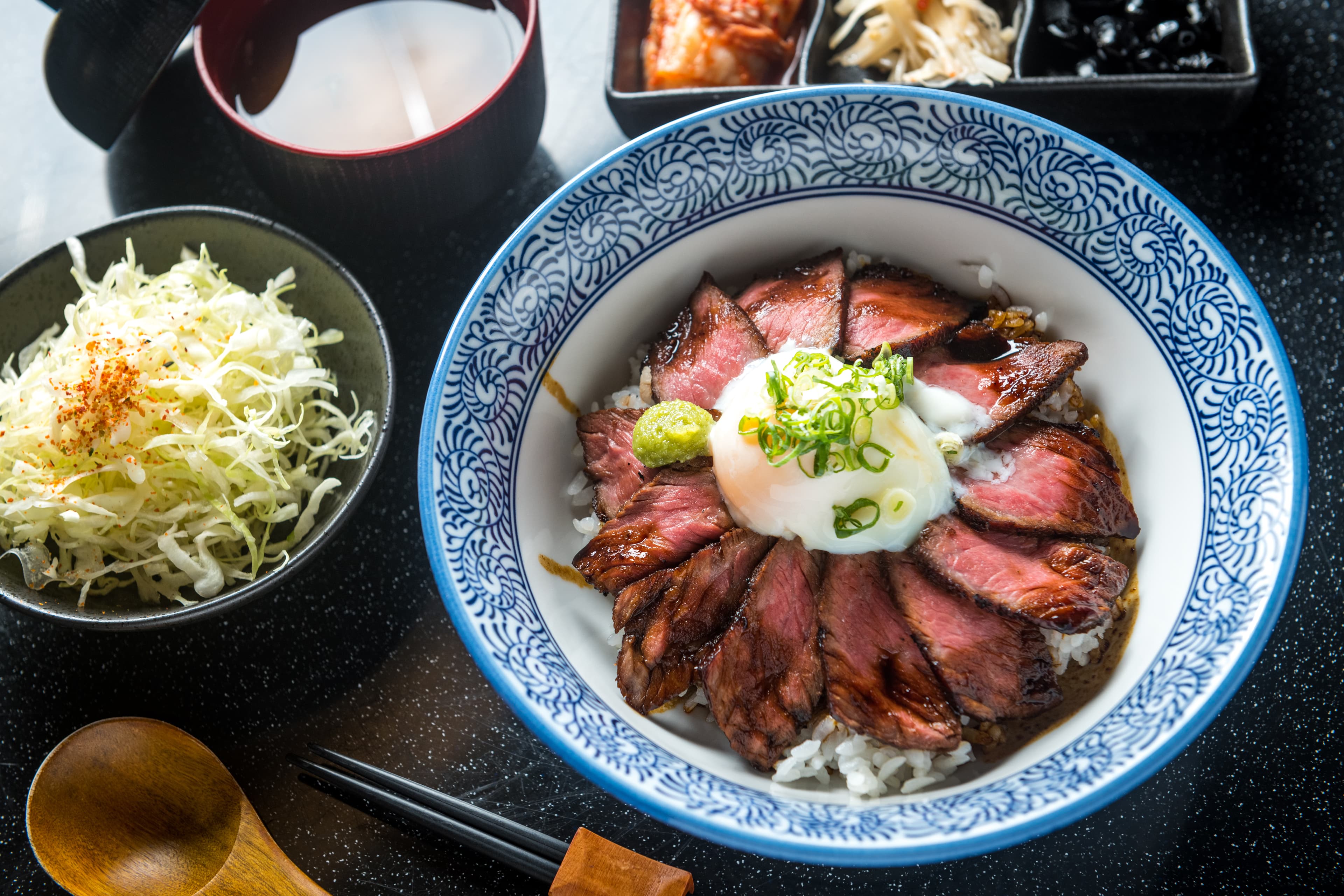「豪華牛排丼定食」舒肥、煎至上色的牛肩胛與半熟蛋的組合，滑潤焦香，太罪惡。（320元／份，商業午餐）