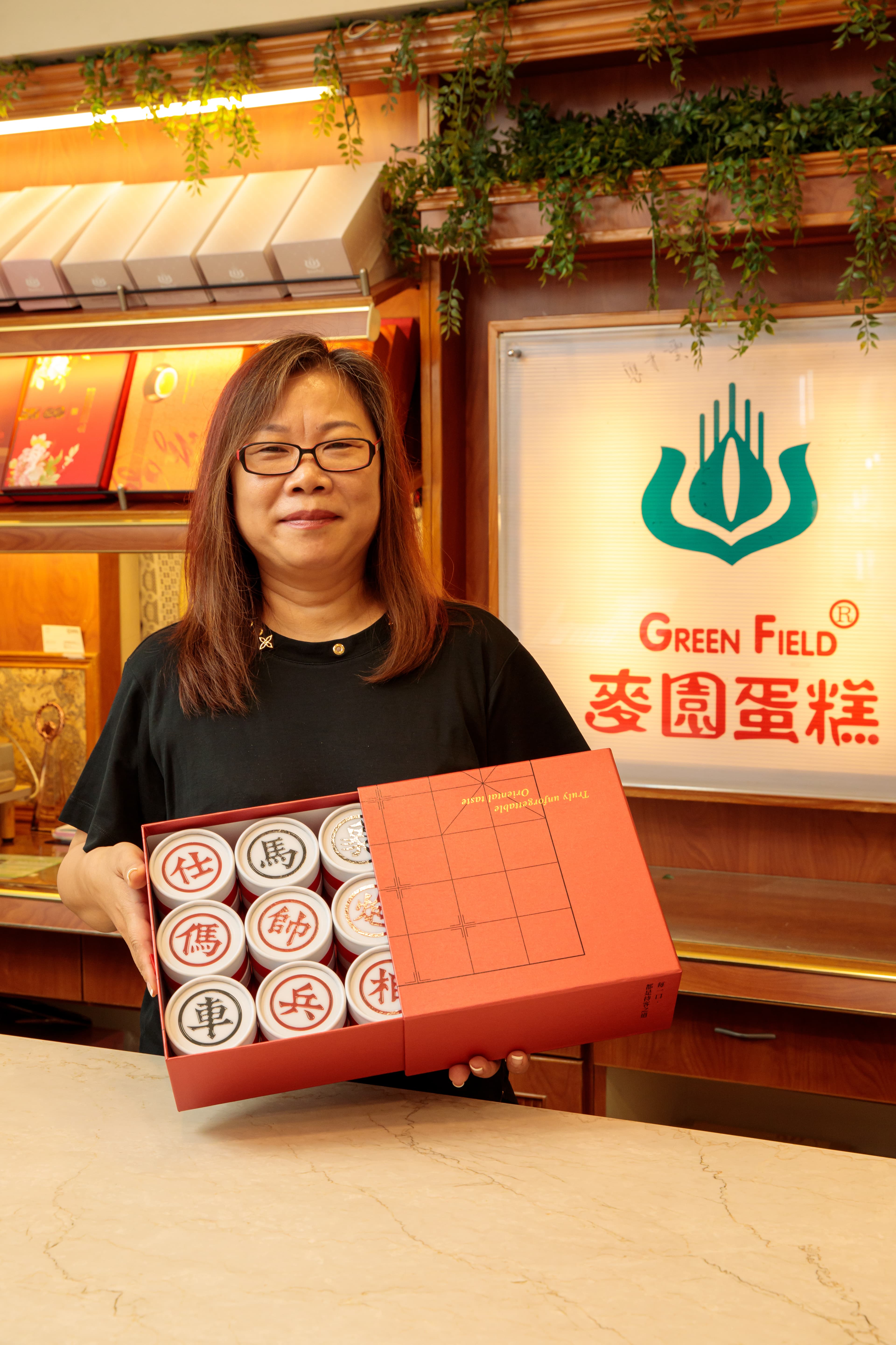 豪爽的老闆娘李素霞得意推銷自家的象棋鳳梨酥禮盒。