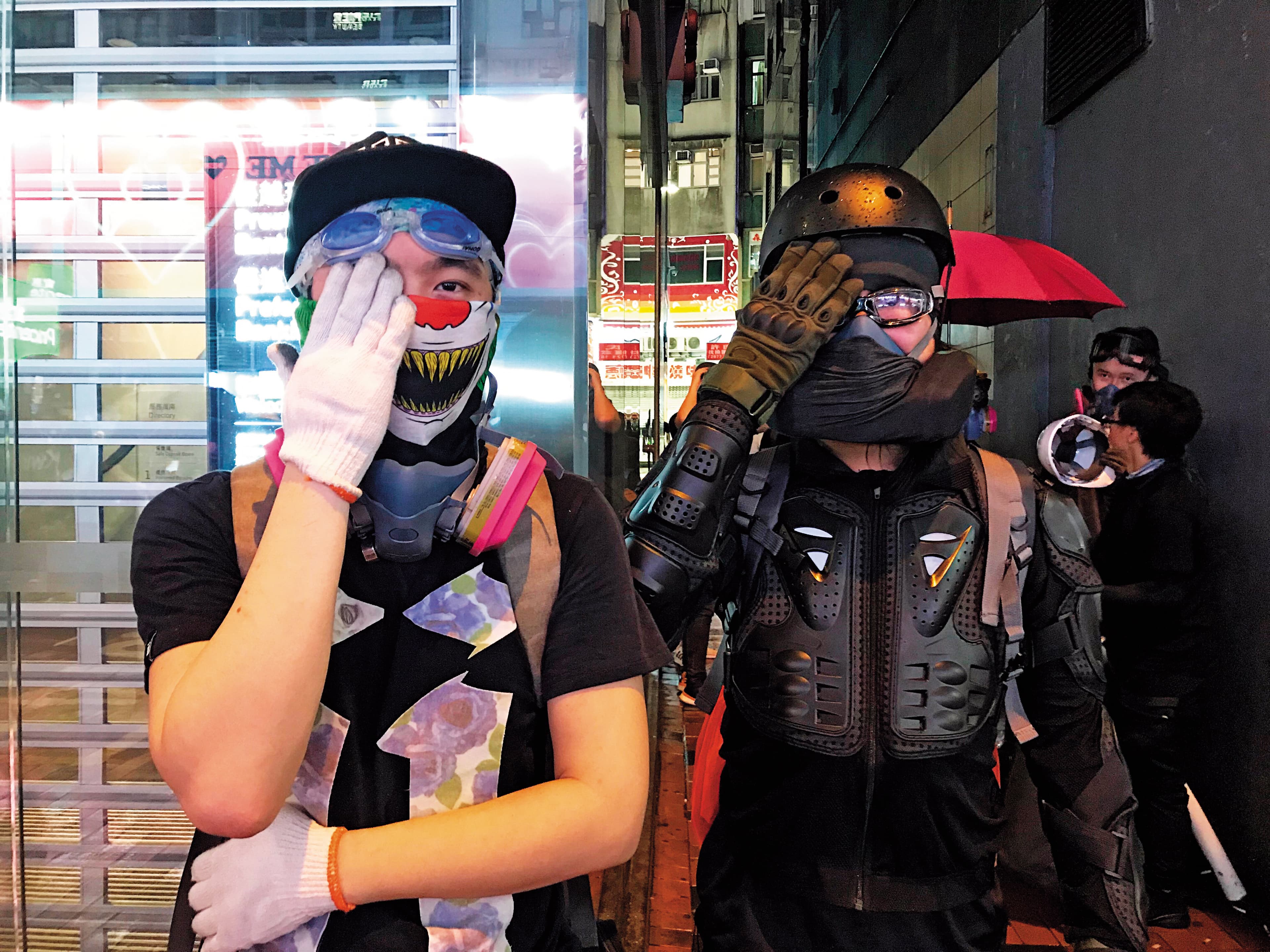 2名勇武派示威者遮住右眼，諷刺警方射傷香港民眾眼睛。（陳虹瑾攝）