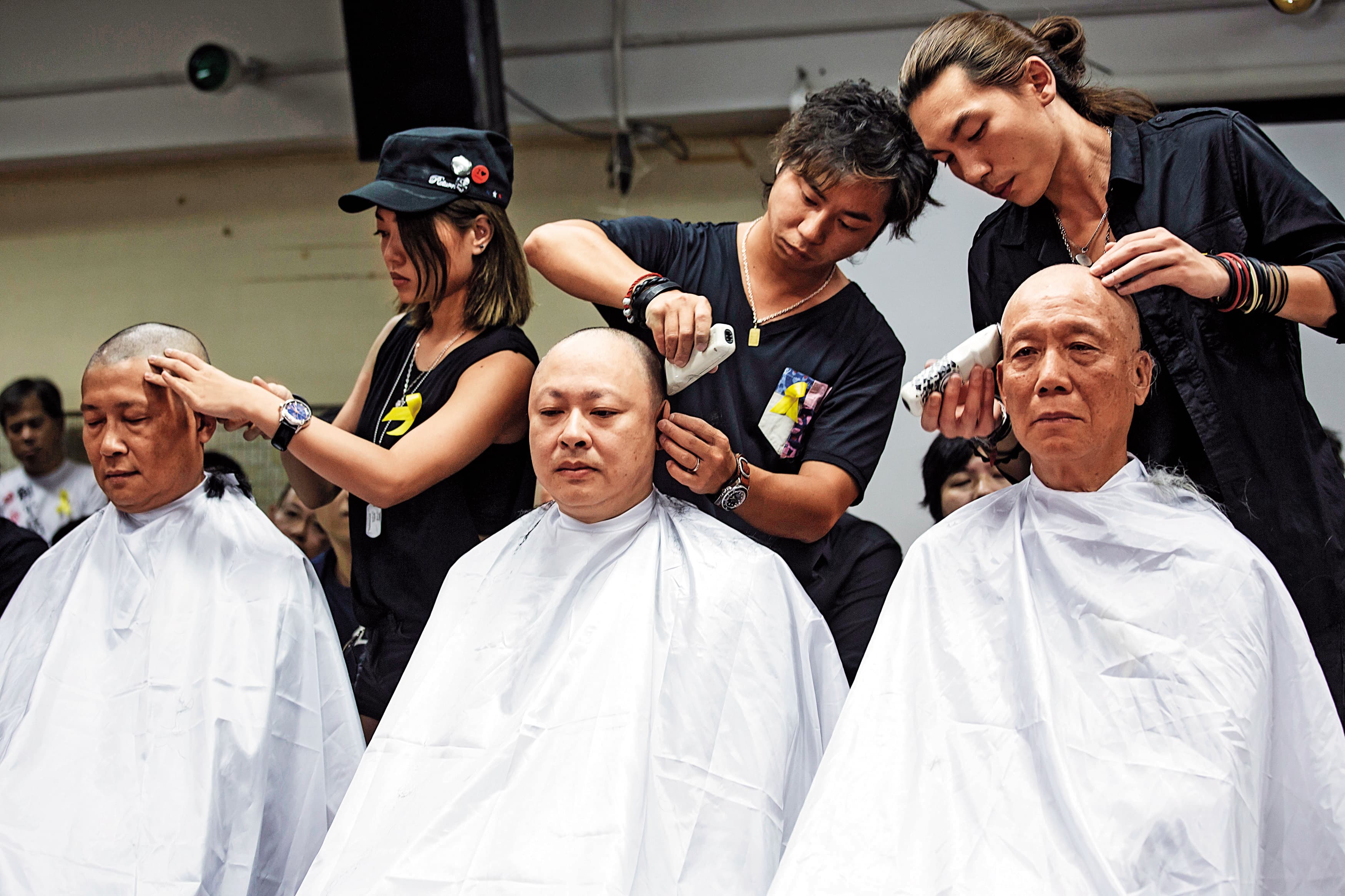 2014年9月，「占中三子」戴耀廷（中）、朱耀明（右）和陳健民（左）帶領一批民眾剃光頭，表達公民抗命、爭取真普選的決心。（達志影像）