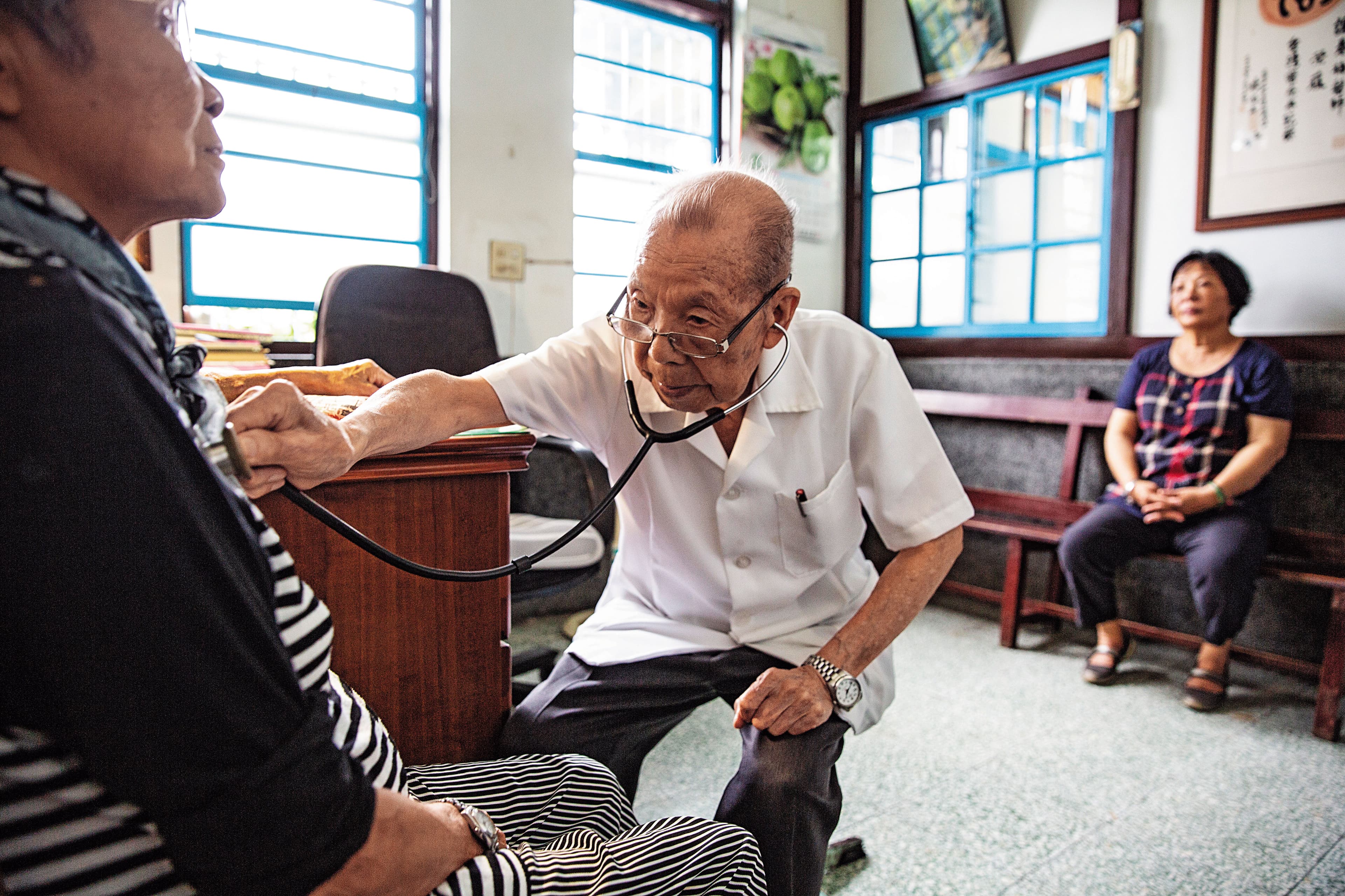 Patients continue to visit her old clinic. The person on the right waiting for treatment is Zhou Yue-lan, who was once close to death due to a difficult birth.