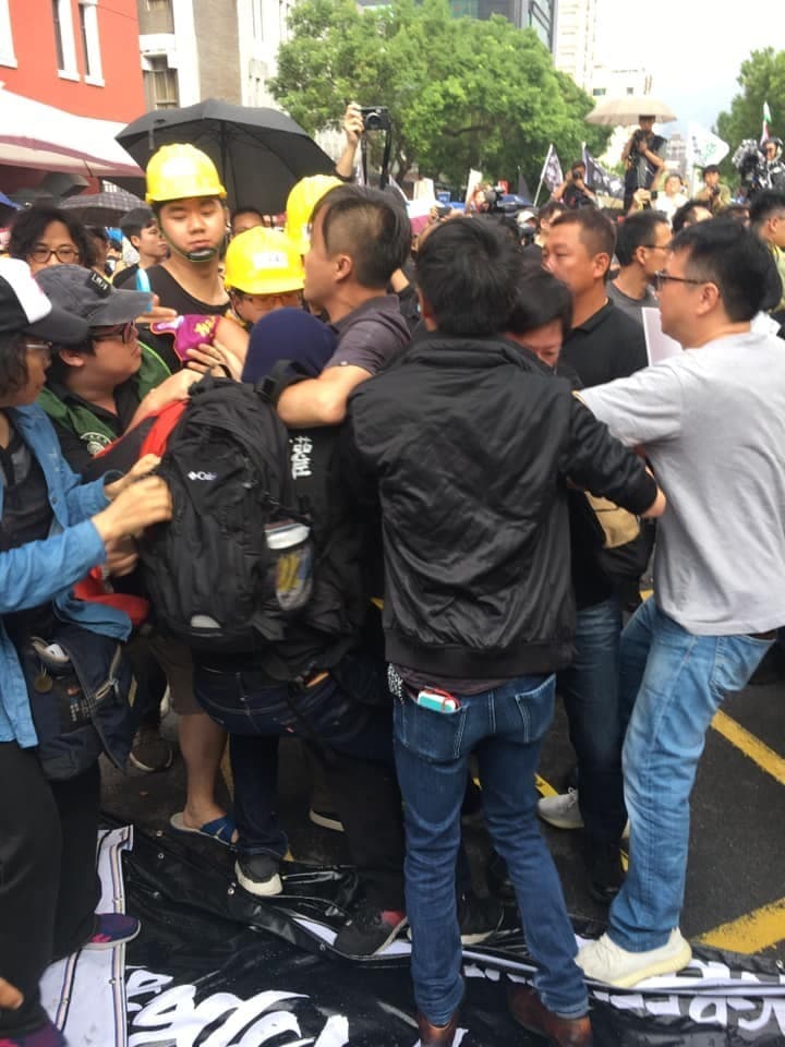 胡嫌滋事後，被參與遊行的民眾壓制。（翻攝畫面）