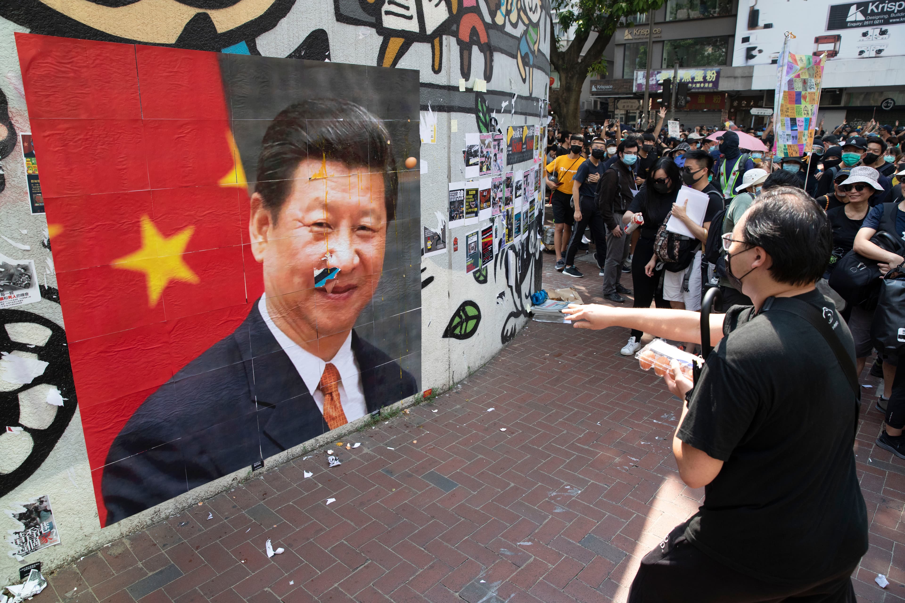 民眾在灣仔人行道外牆張貼習近平照片，並輪流丟擲雞蛋。
