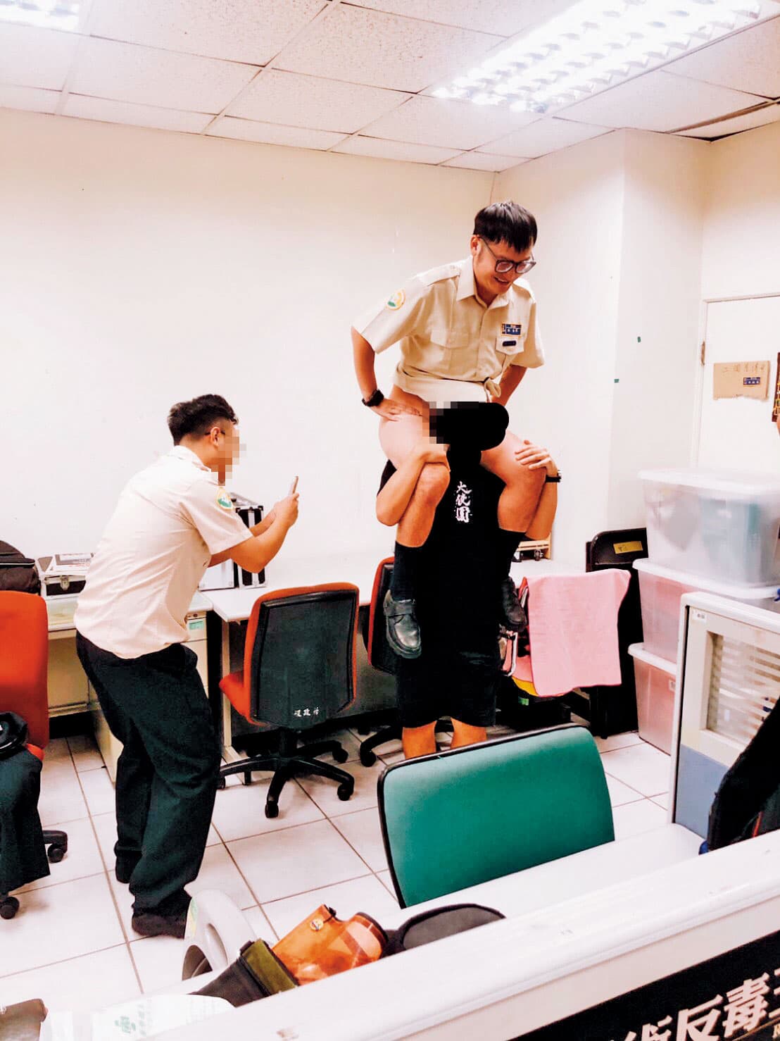 KID（右）在辦公室內，裸臀騎在同袍身上，其他人則起鬨拍照。（讀者提供）
