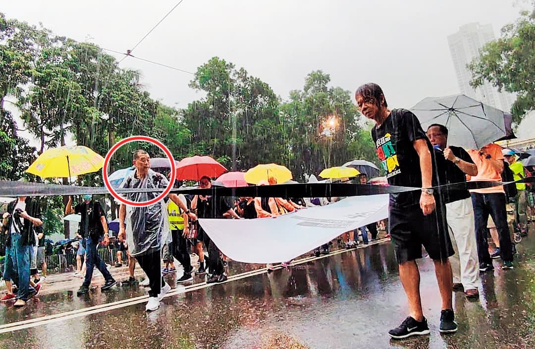 今年8月18日，港人冒雨上街遊行，黎智英（紅圈處）與前立法會議員梁國雄（右）走在隊頭。（翻攝梁國雄臉書）