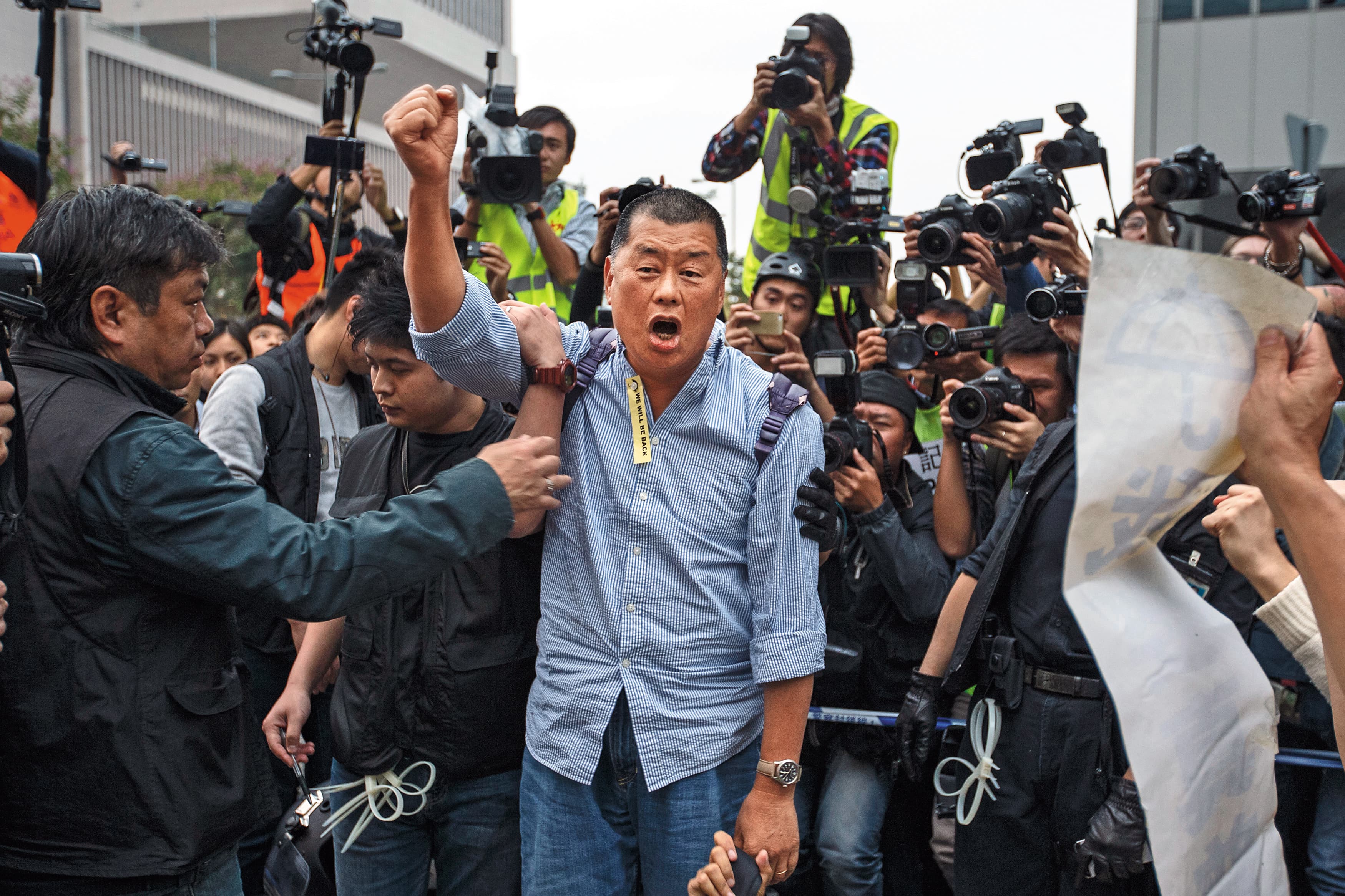 2014年12月11日，占中行動遭到警方強行清場，黎智英堅持在港島金鐘占領區內留守，當他遭警員押走時，仍高喊抗爭口號。（達志影像）
