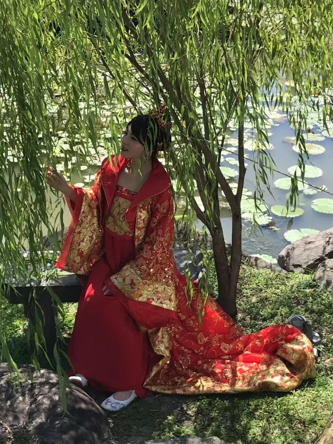 上原亞衣穿著大紅色古裝在樹下乘涼。（讀者提供）