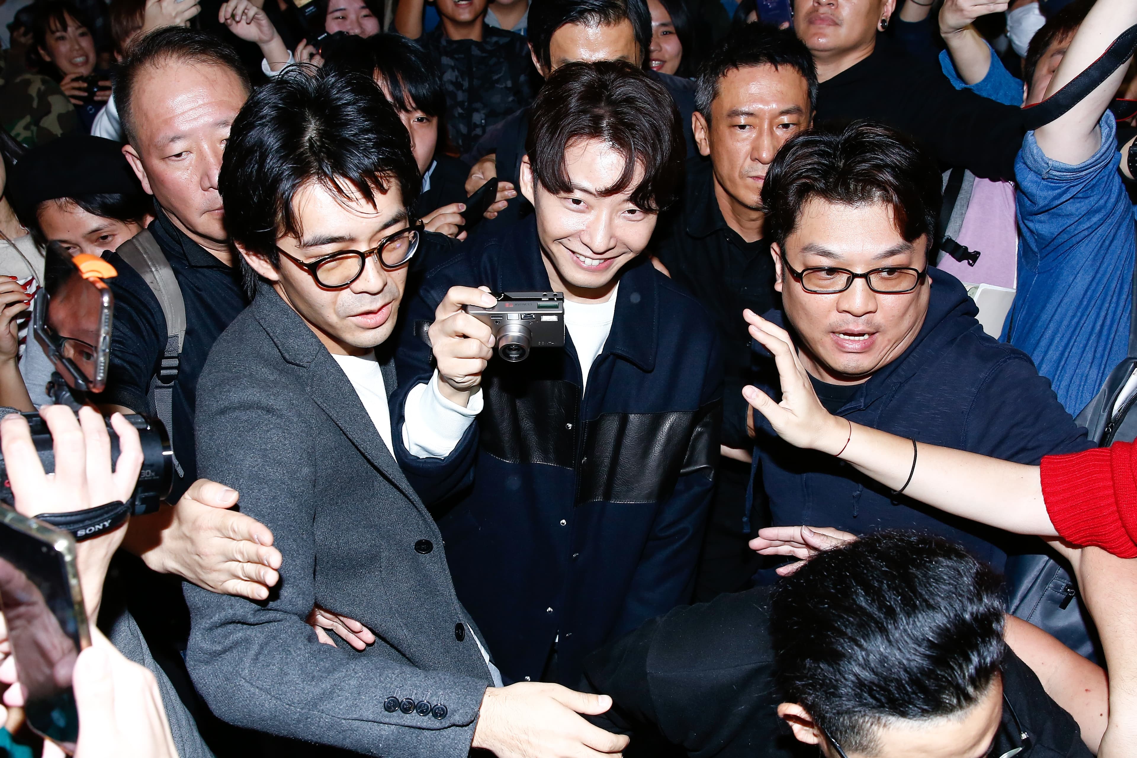星野源開心拿著隨身相機拍照。