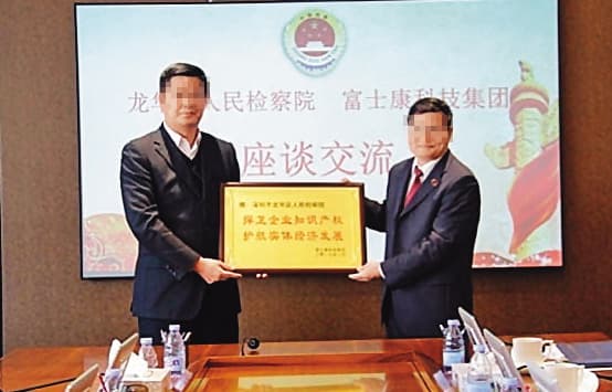 Ｘ先生提及的吳姓陸幹（左），除了具有中共人大代表的身分外，更曾代表富士康向檢察院贈送匾額。（翻攝網路）