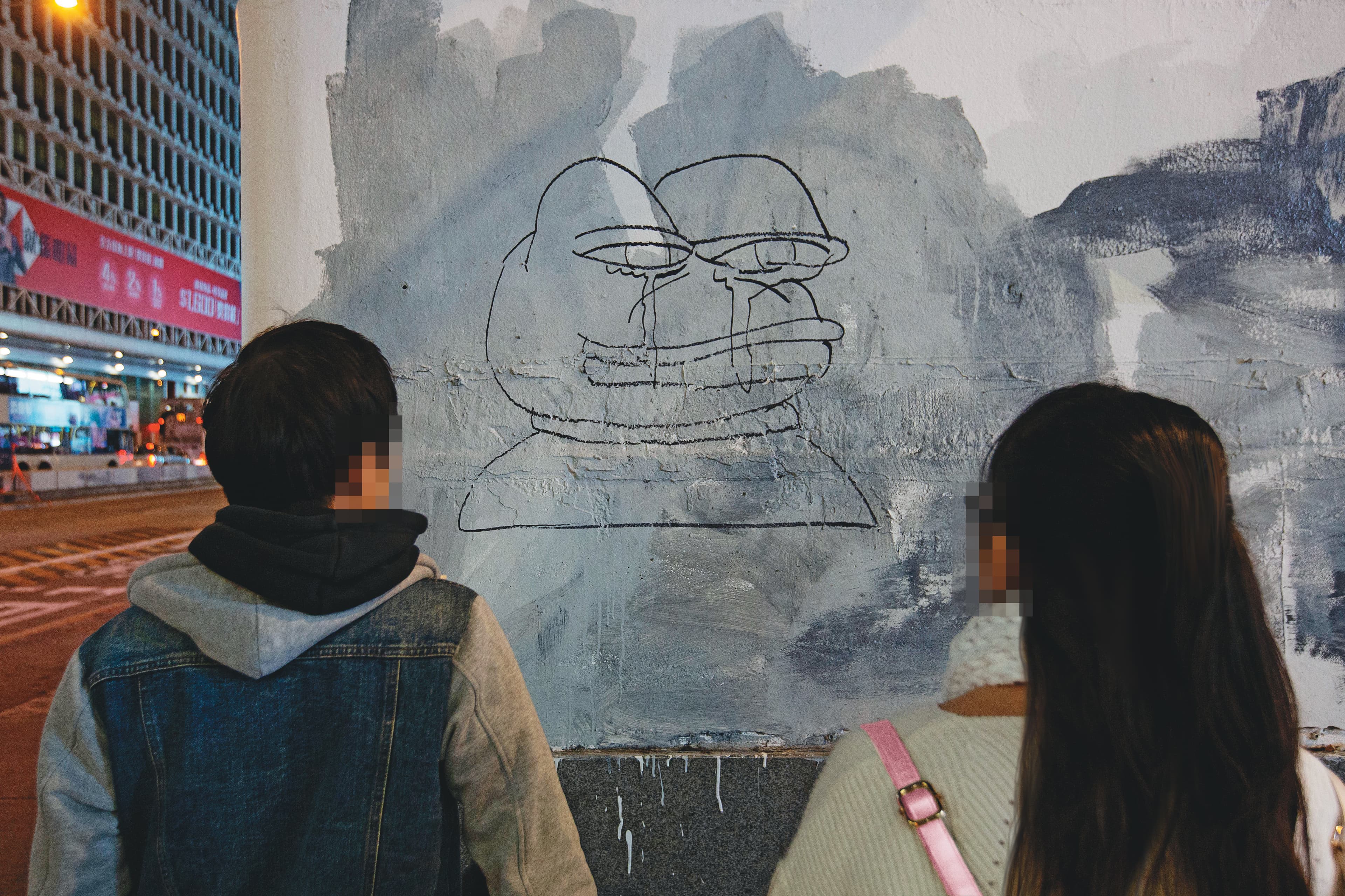 阿絲（右）和阿巴（左）駐足旺角街頭，停在反送中活動經常看到的「Pepe蛙」塗鴉前。