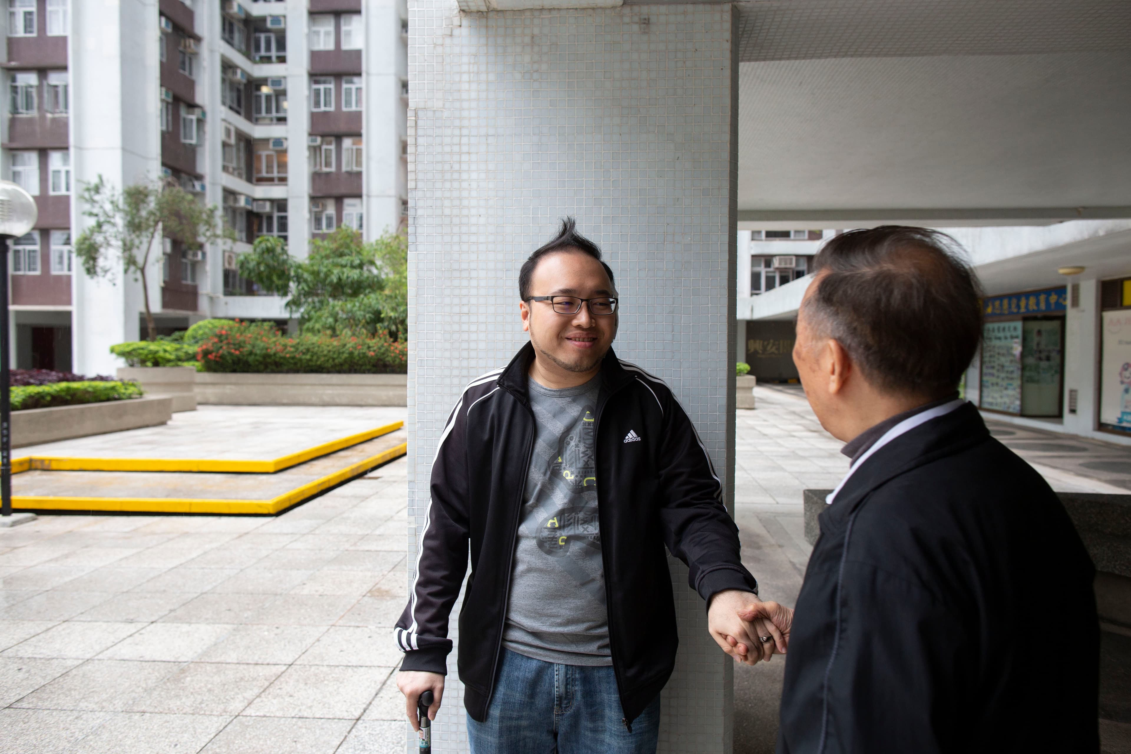趙家賢在太古城接受訪問，此時一名看著他長大的長者過來向他致意。