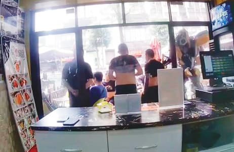 鄭姓處長要求陳姓台商（左1）在店門口罰站，恐嚇他支付高額賠償金。（投訴人提供）