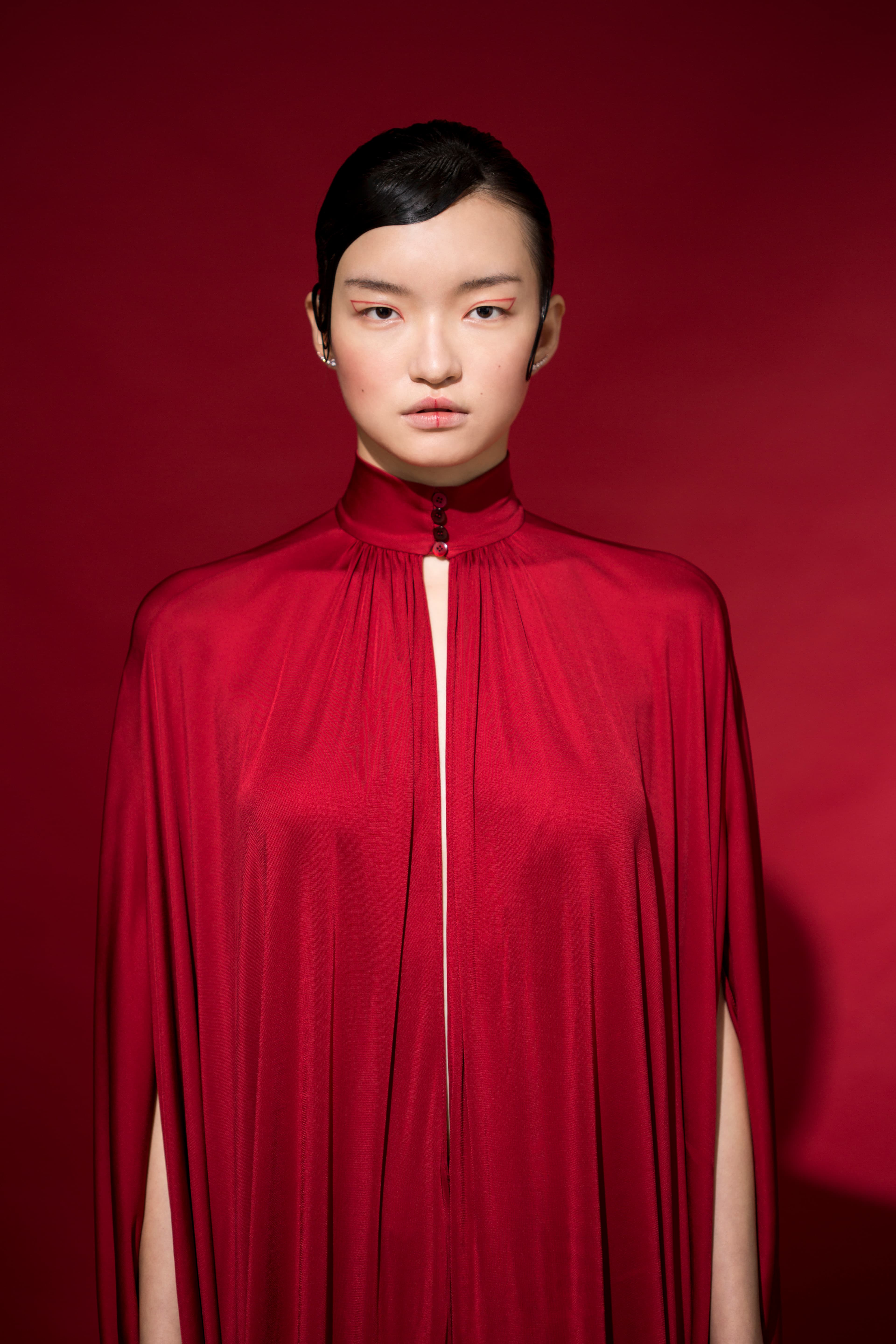 斗篷式紅色洋裝 價格店洽 by VALENTINO MOONSUN／穿孔耳環 NT$4,490 by SWAROVSKI