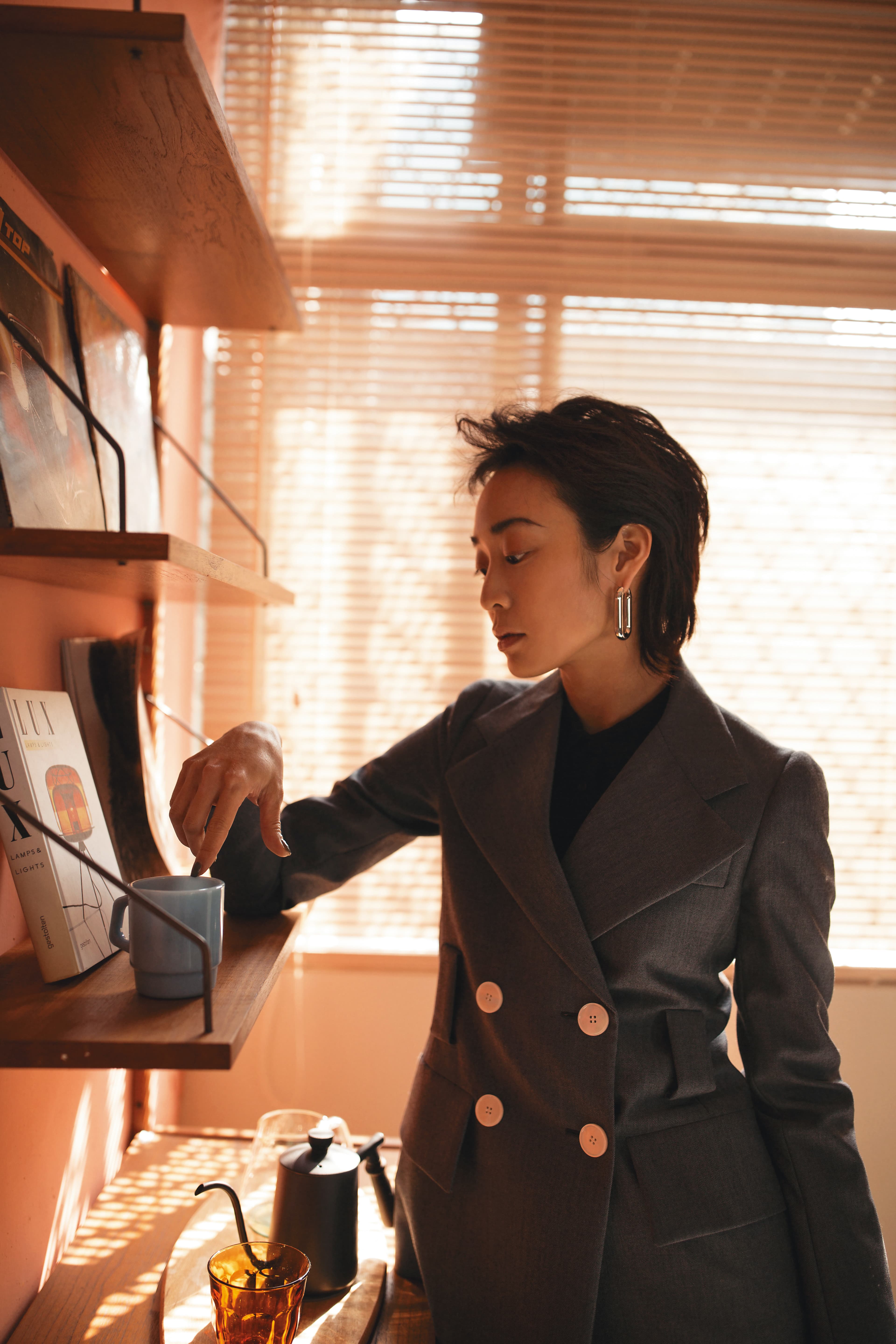 灰色雙排釦西裝外套 價格店洽 by PRADA；黑色襯衫 價格店洽 by PRADA；銀色單圈耳環 價格店洽 by FENDI。
