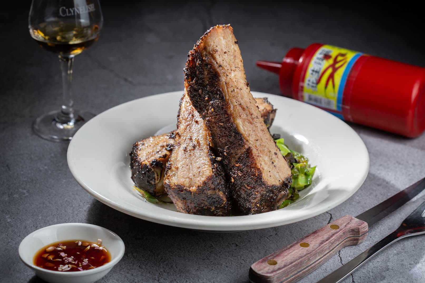 裹辛香料烤得焦酥腴嫩的「豬肋排」搭配油蔥醋十分對味。（620元／份）