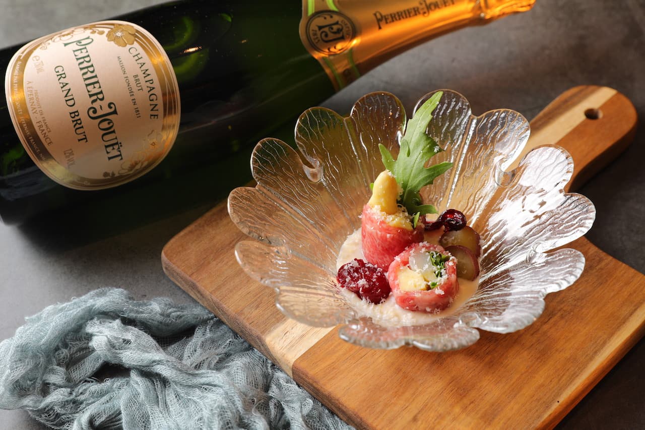 年輕香檳「Perrier Jouet Grand Brut」（2,700元／瓶）活潑、帶柑橘酸味，和冷菜「蔬食佐肩捲」（320元／份）很相襯。