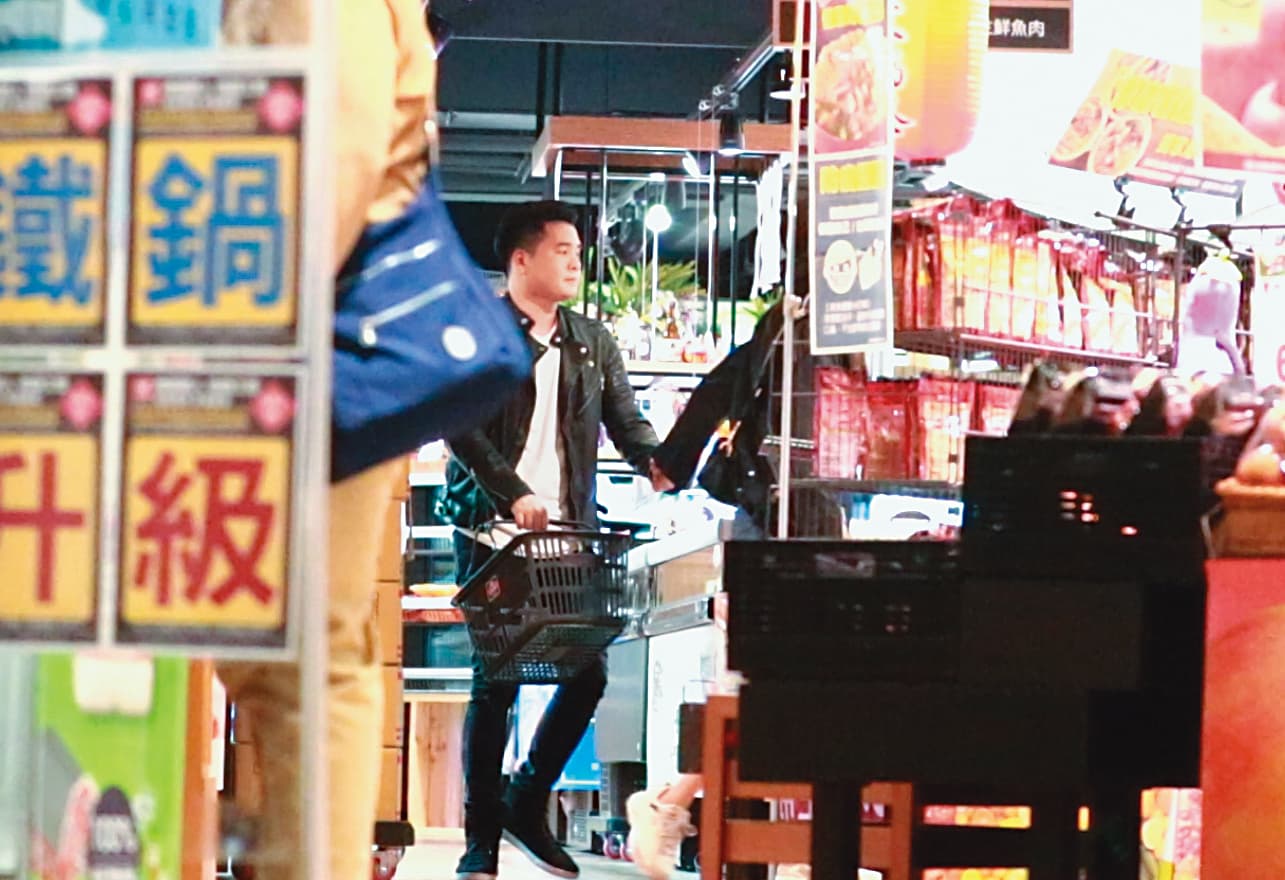 2／12 22：45，逛超市時，陳育涵忍不住伸手去牽皮衣男的手。