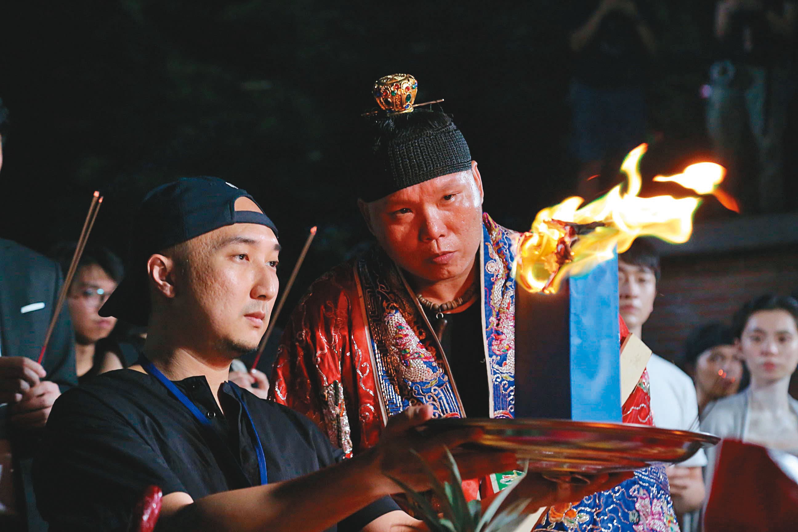 經驗豐富的宗教顧問龍哥（前右）在拍片現場把關，讓導演奚岳隆（前左）與劇組平安拍攝。（傳影互動提供）