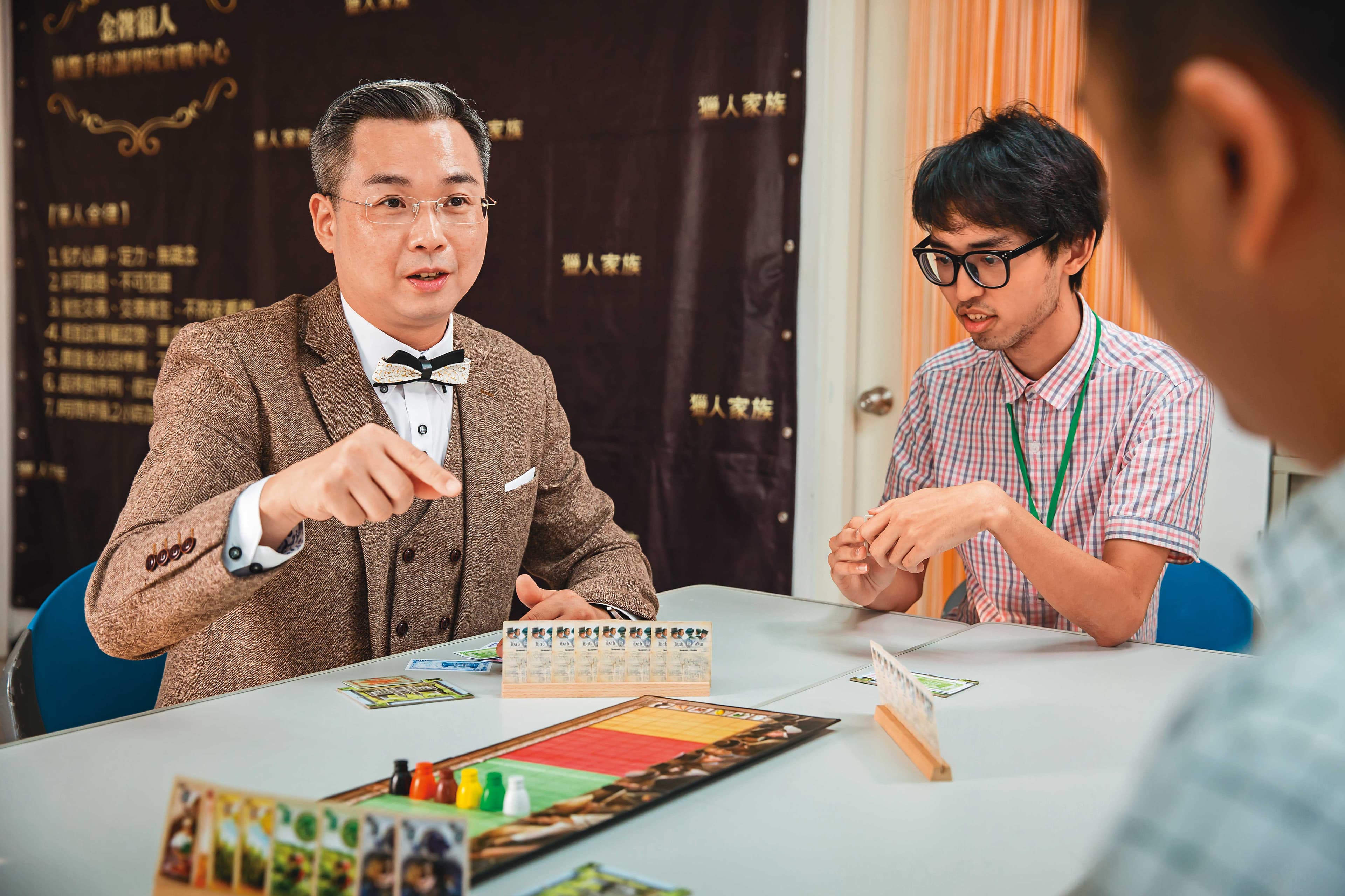 朱晏廷（左）熱愛玩桌遊，並透過桌遊讓學生認識價格波動與資金分配的重要。