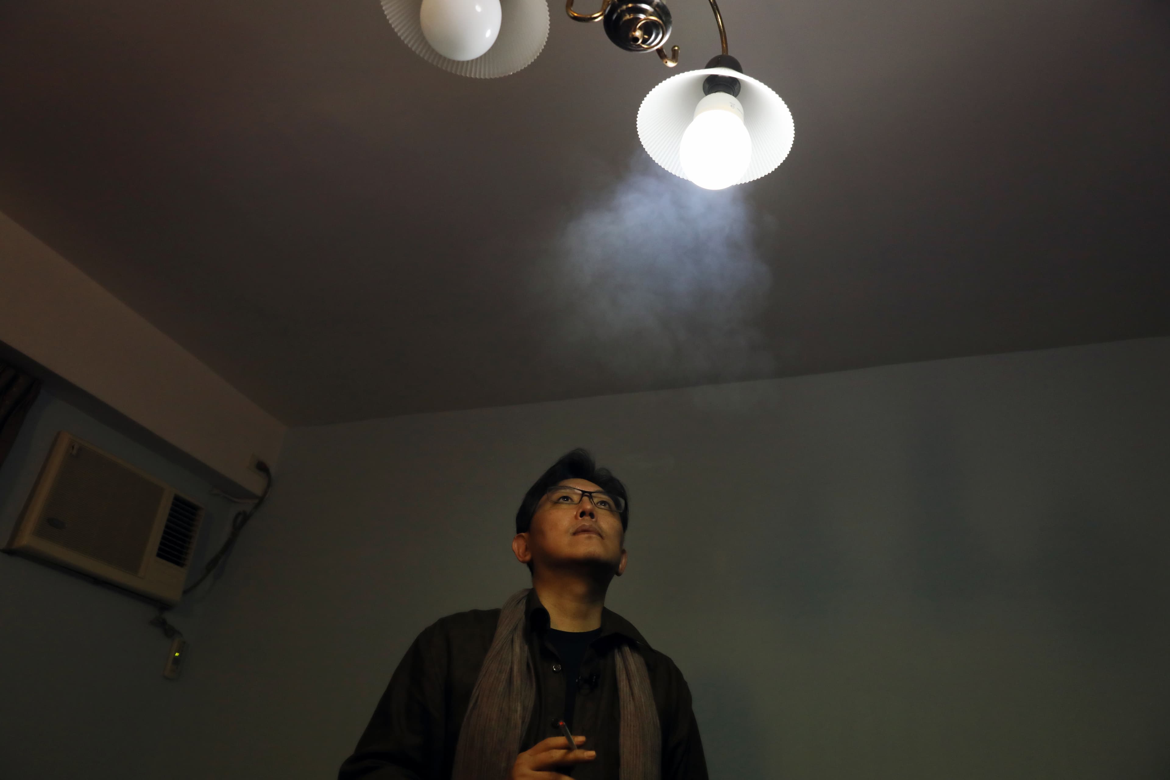 郭強生抽菸。他的老家空闊，家具或許隨家人的離散也按次減少，在空屋裡，他用創作和自己對話。