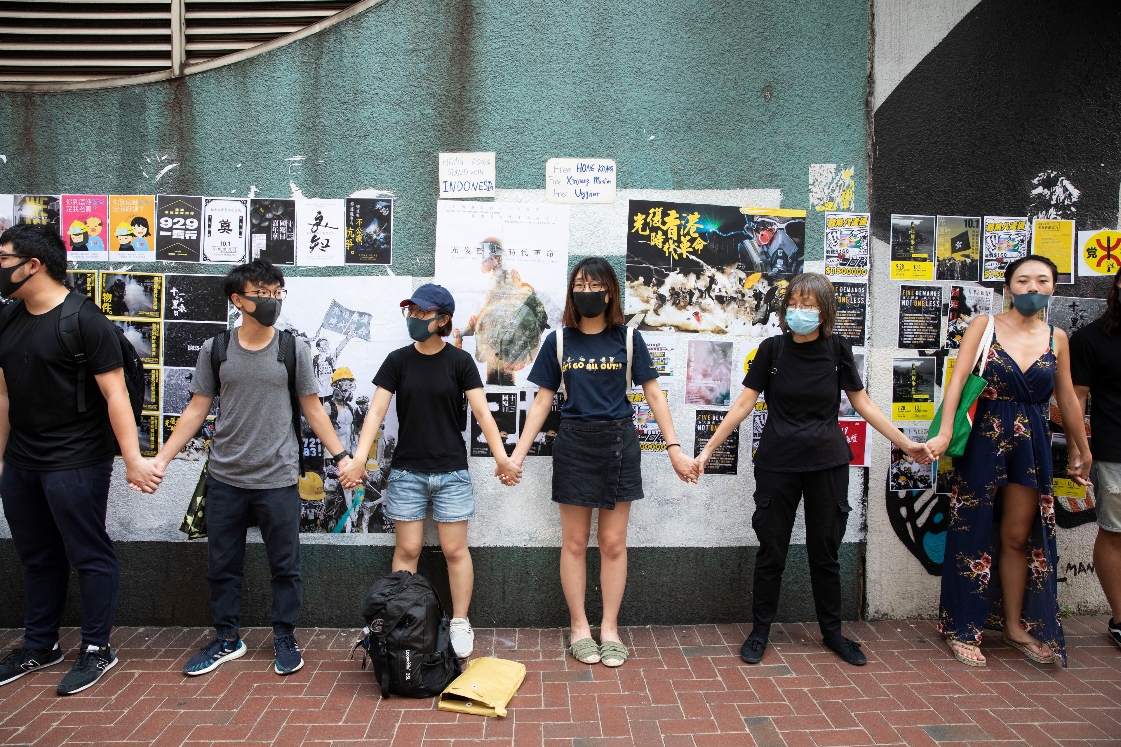 香港年輕勇武派大逃亡，不少人怕被秋後算帳，選擇前往台灣。圖為去年反修例運動期間，年輕的香港市民在香港修頓球場連儂牆牽起手。（本刊資料照）