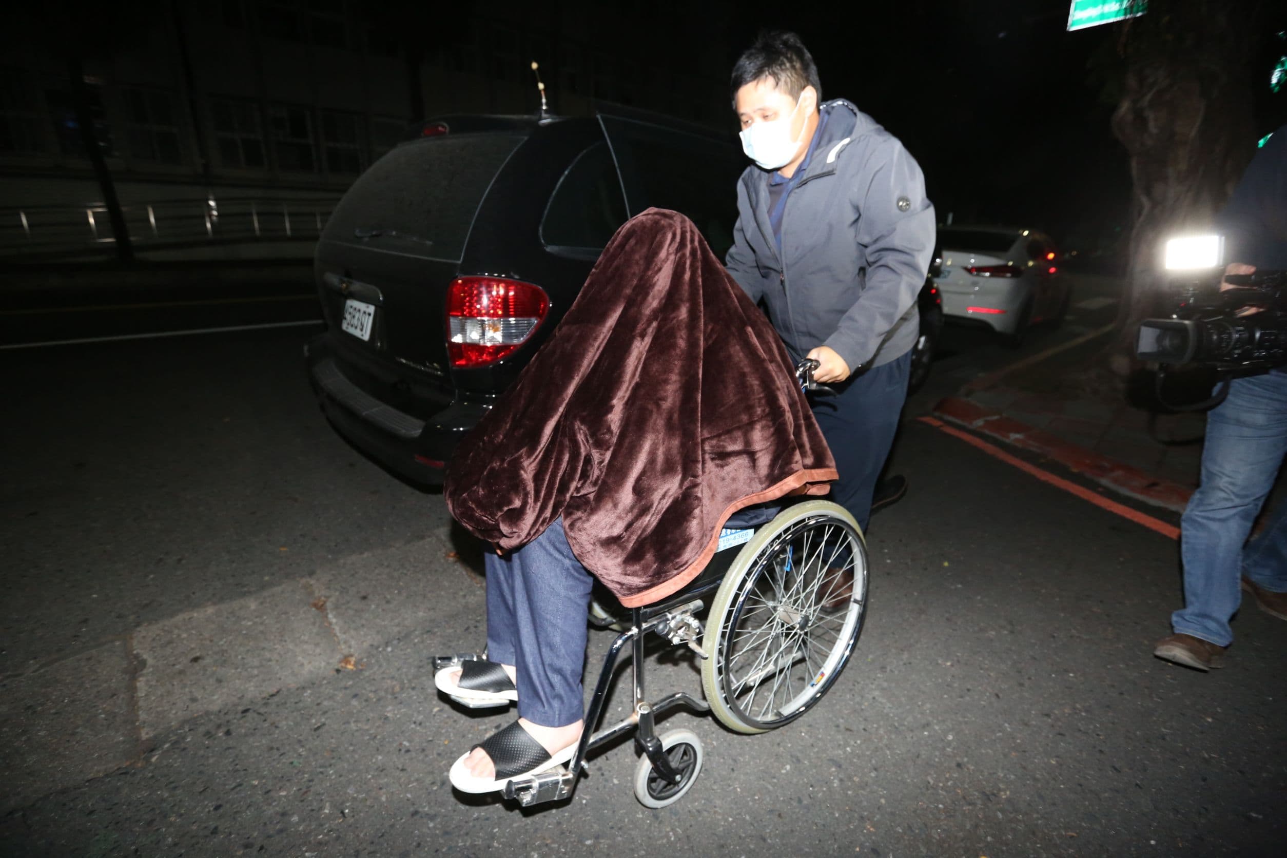 騙扁小子黃琪（前）涉嫌向中衛詐口罩，遭聲押禁見，坐在輪椅用毯子蓋住頭。