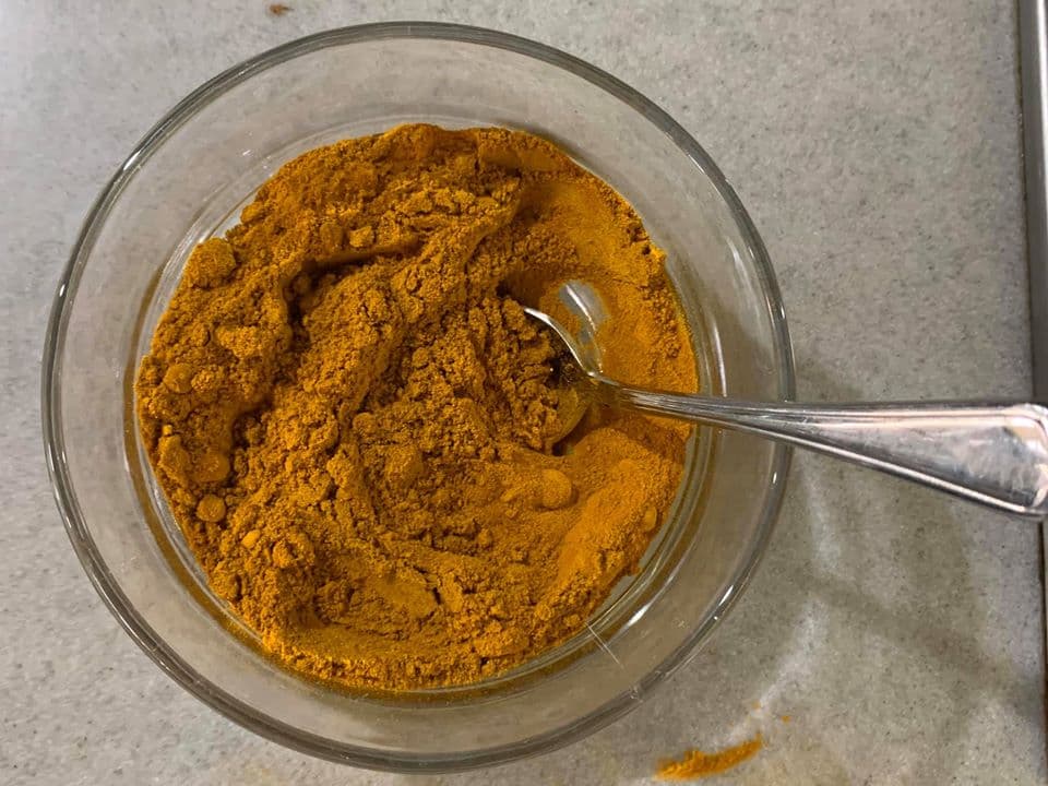 大量的薑黃粉與咖哩粉倒成一碗，比例約一半一半。