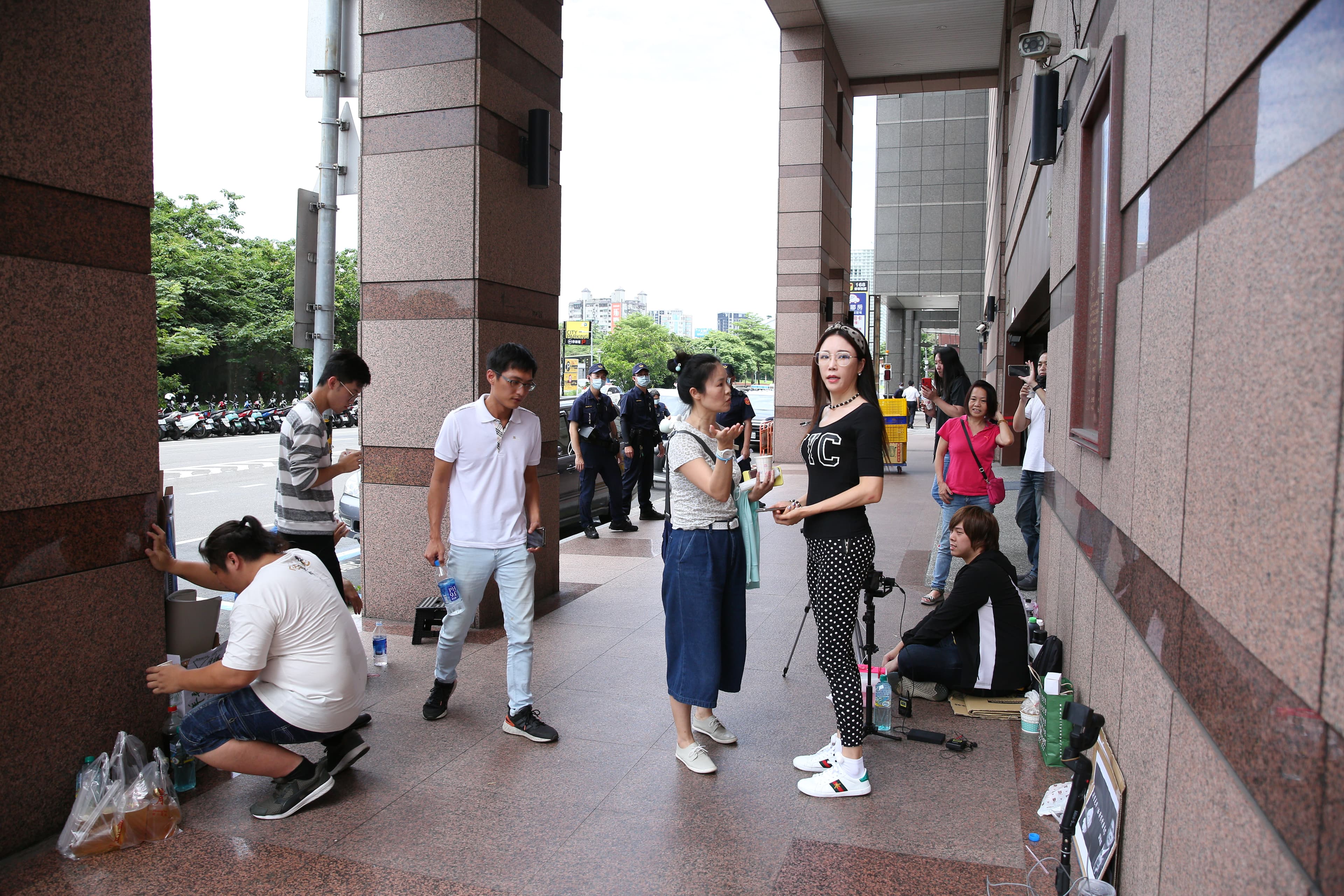民進黨中央黨部樓下出現挺韓網紅攜帶悼念許崑源手板、直播器材前往直播。