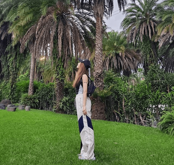蔡依林穿無袖背心、寬鬆運動褲，仰頭望著椰子樹，享受大自然的美。（翻攝自蔡依林IG）